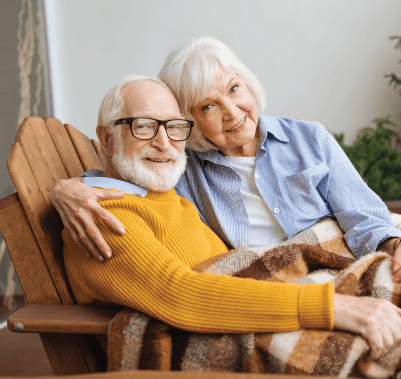 A man and a woman are hugging each other and smiling.