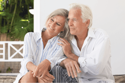 A man and a woman are sitting next to each other on a porch.