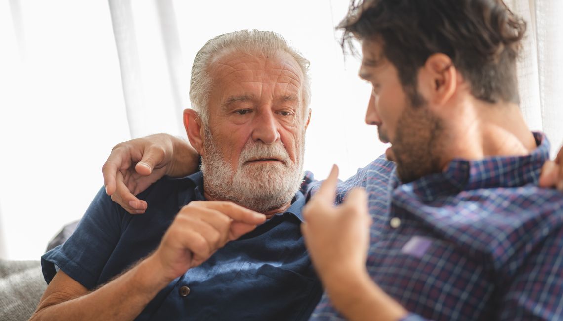 Padre e hijo compartiendo un momento íntimo que representa la guía paterna y el duelo.