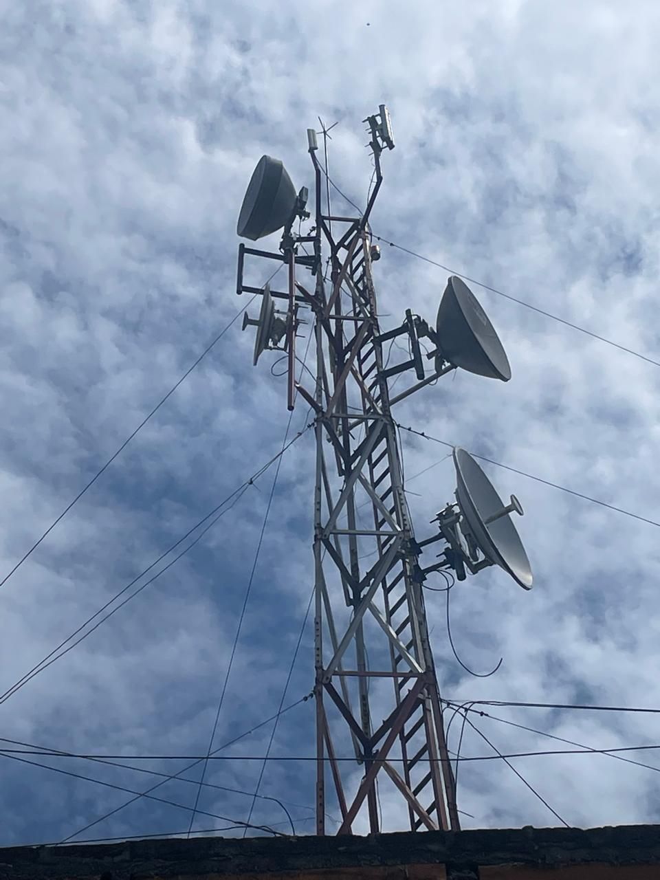 Una torre telefónica con antenas parabólicas en la parte superior.