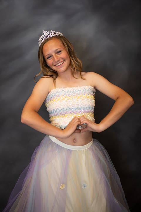 Girl wearing tiara making heart shape with hands