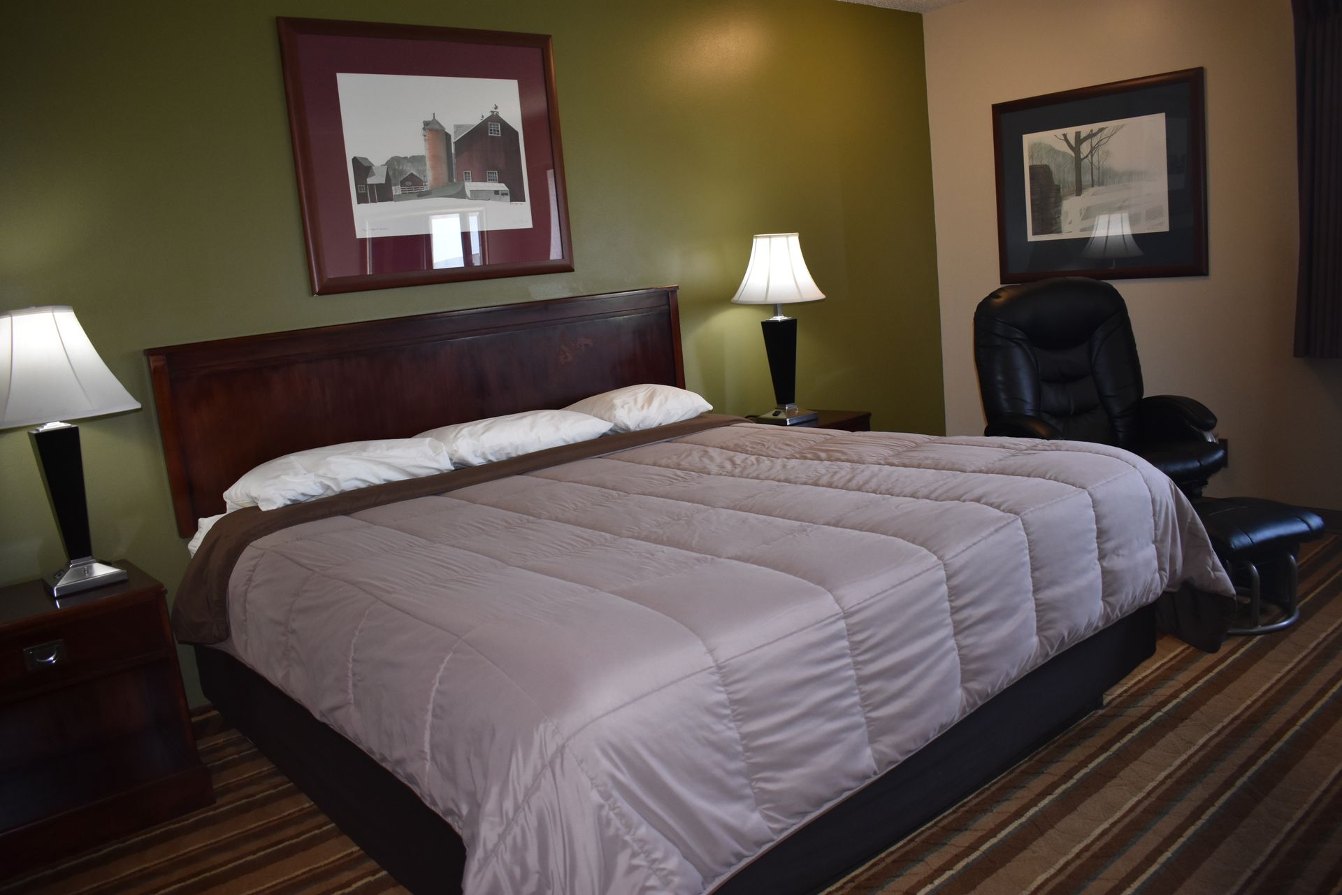 A hotel room with a king size bed and two lamps