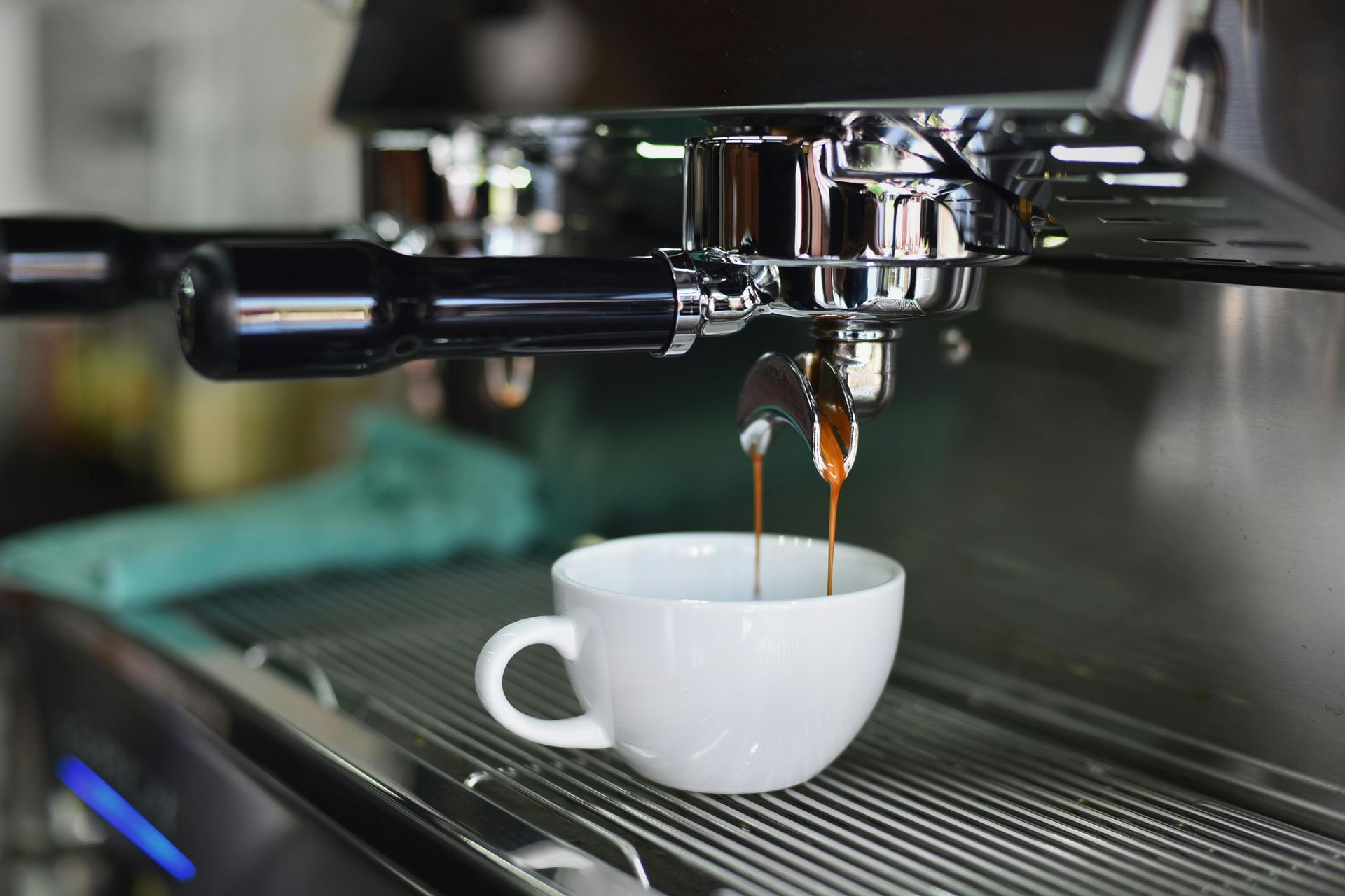 A cup of coffee is being poured from a coffee machine.