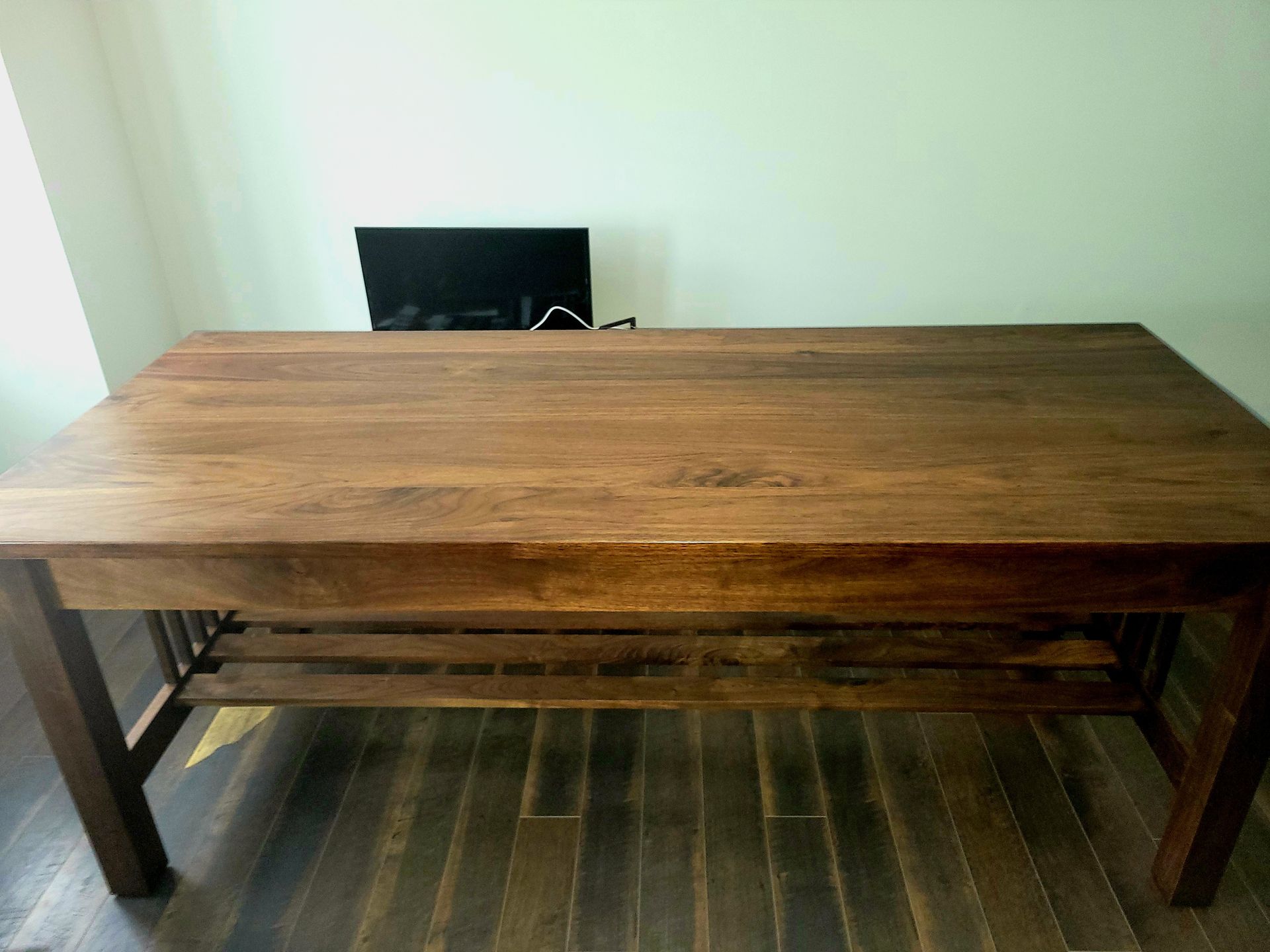 A wooden table is sitting on a wooden floor in a room.