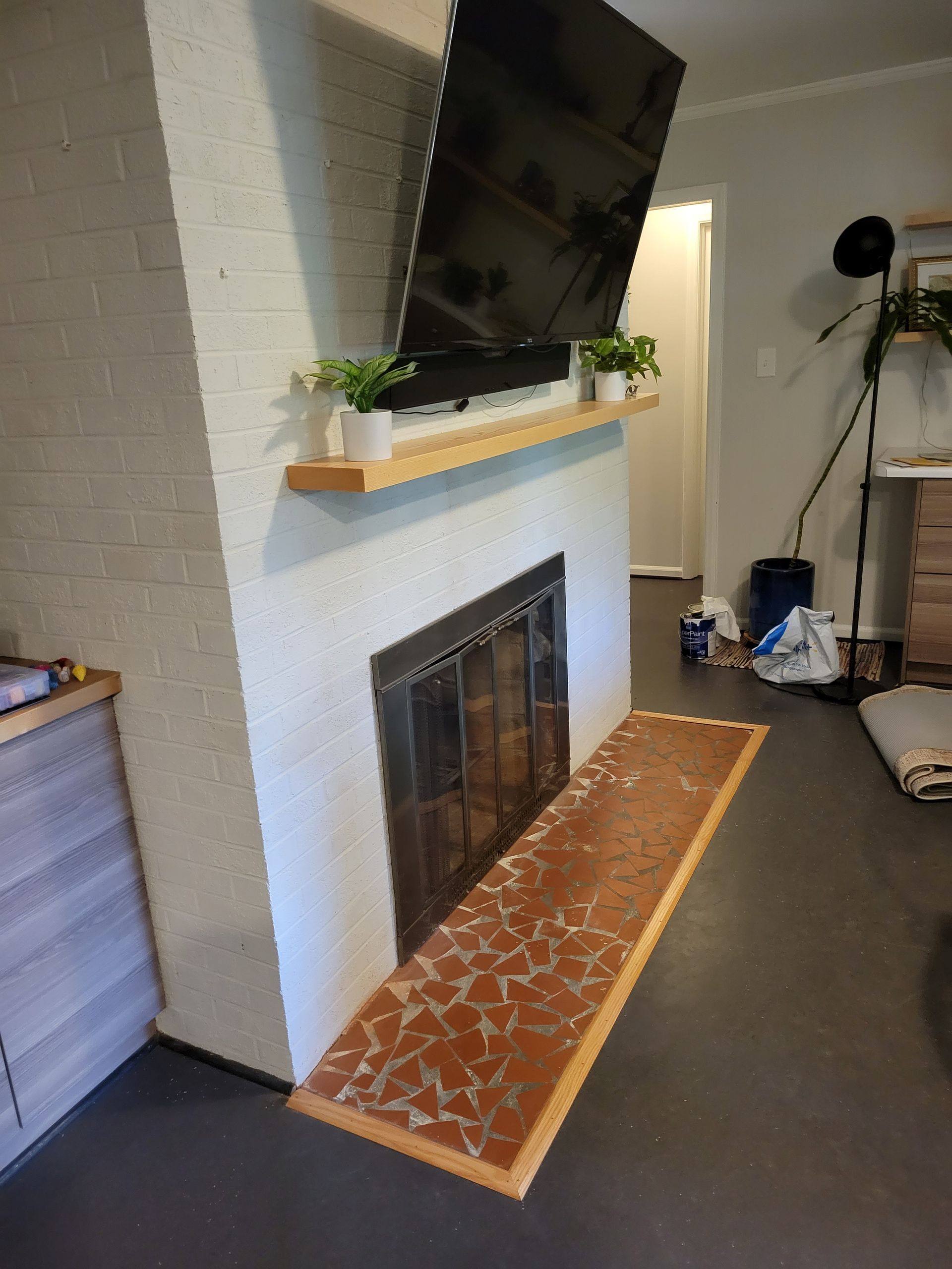 A living room with a fireplace and a flat screen tv mounted on the wall.
