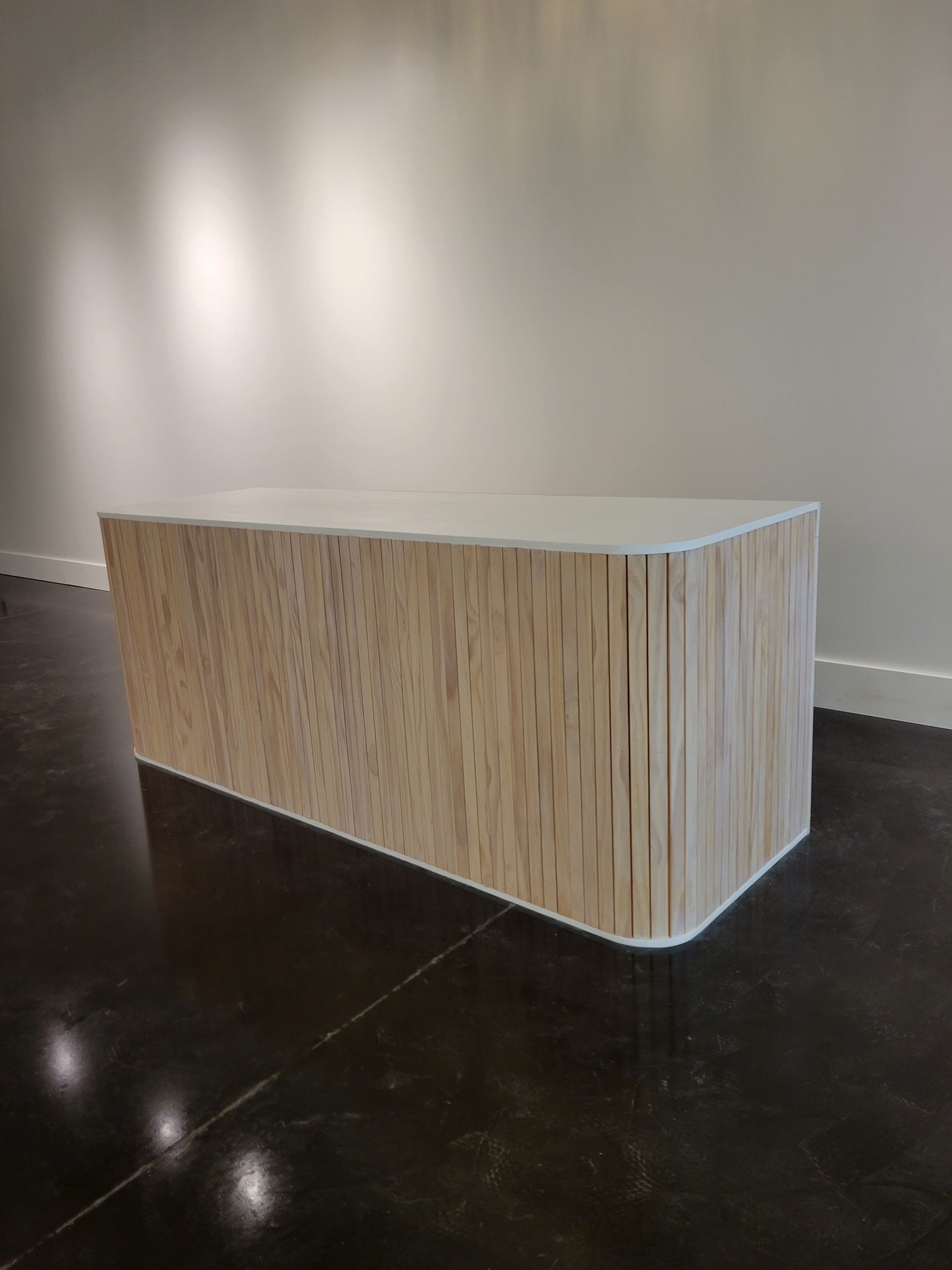 A wooden bench is sitting in a room next to a wall.