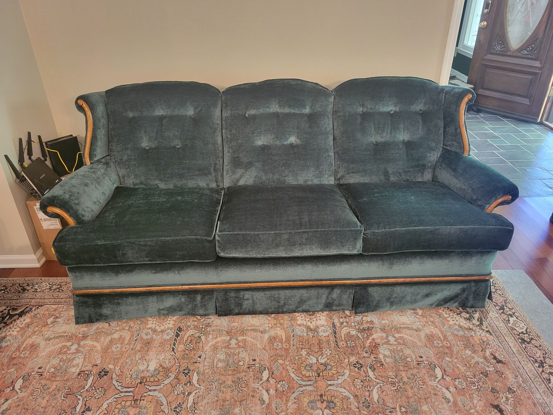 A green couch is sitting on a rug in a living room.