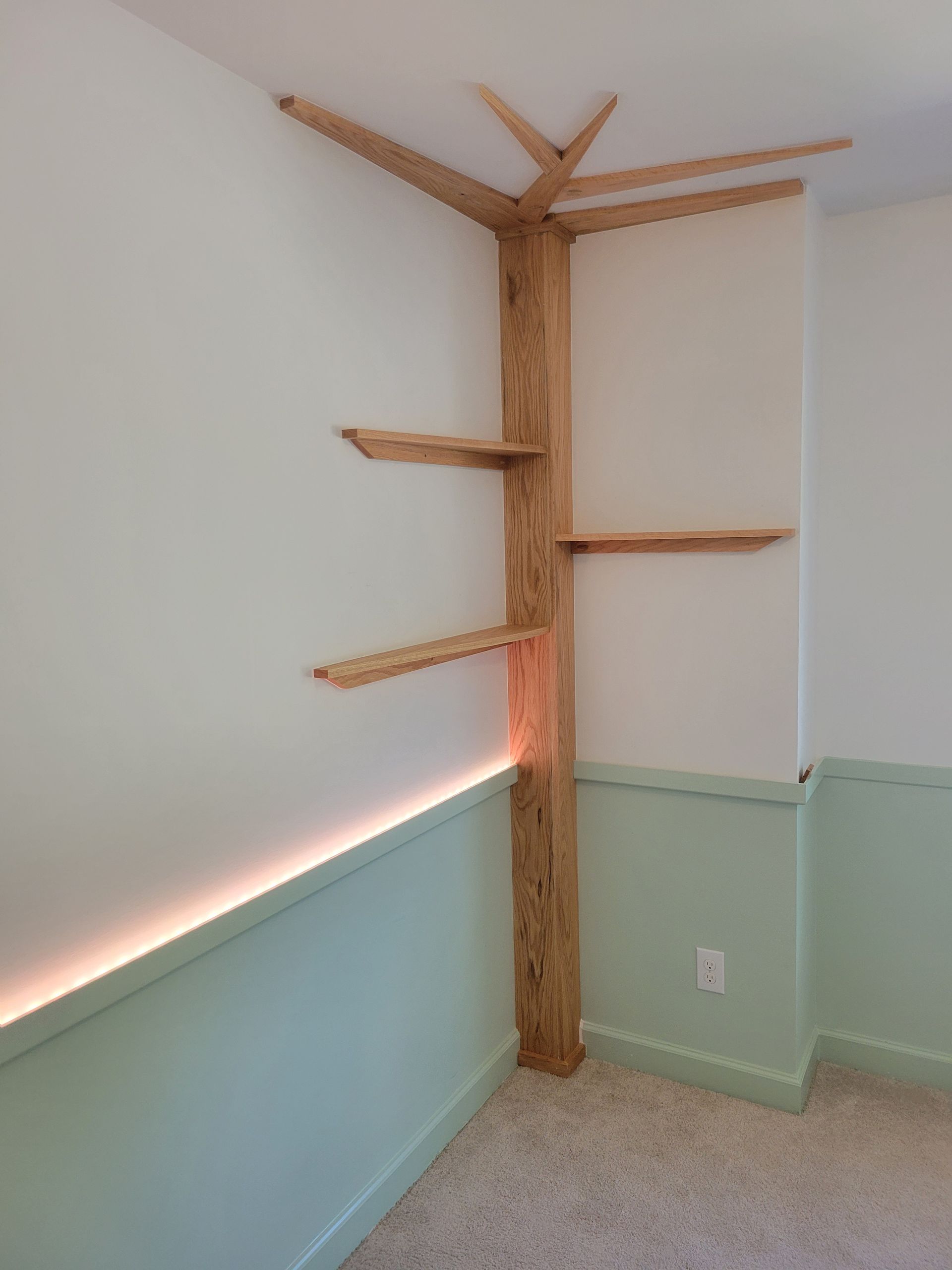 A room with a tree shaped shelf in the corner