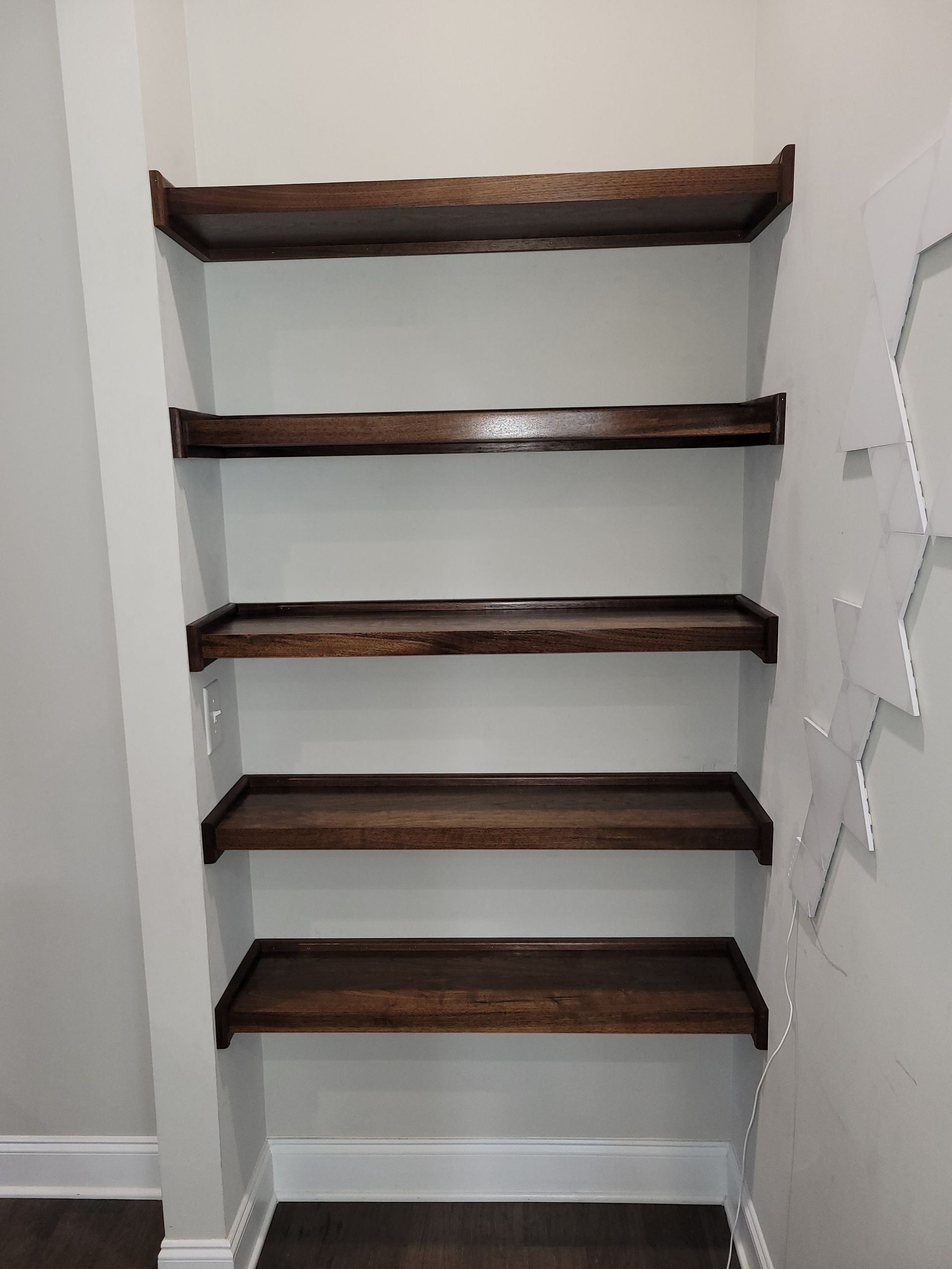 A closet with wooden shelves and a white wall.