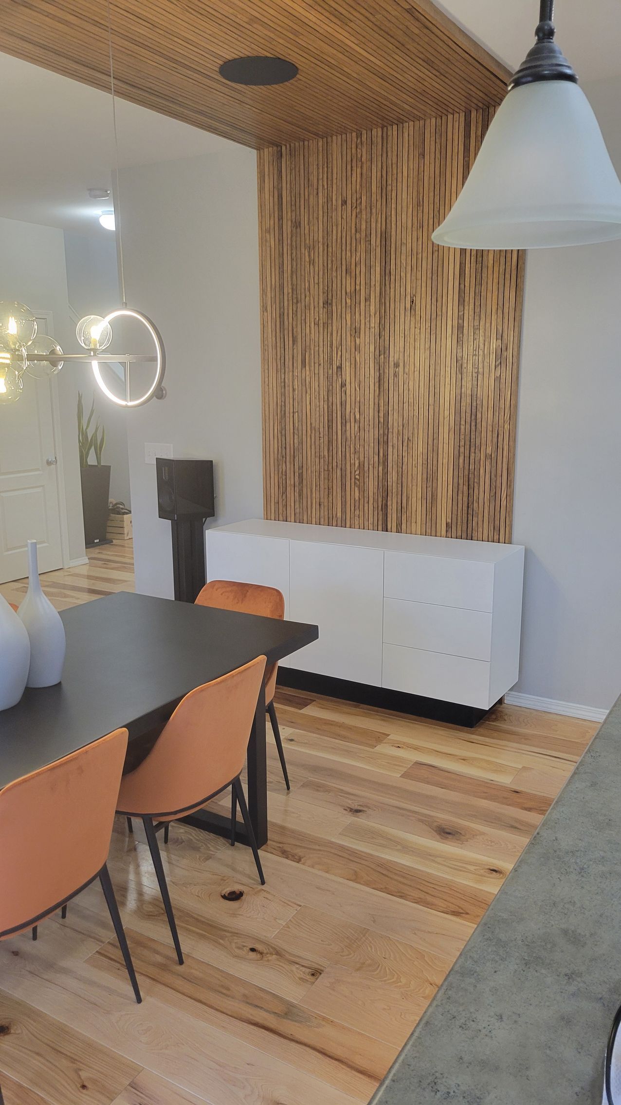 A dining room with a table and chairs and a wooden floor.