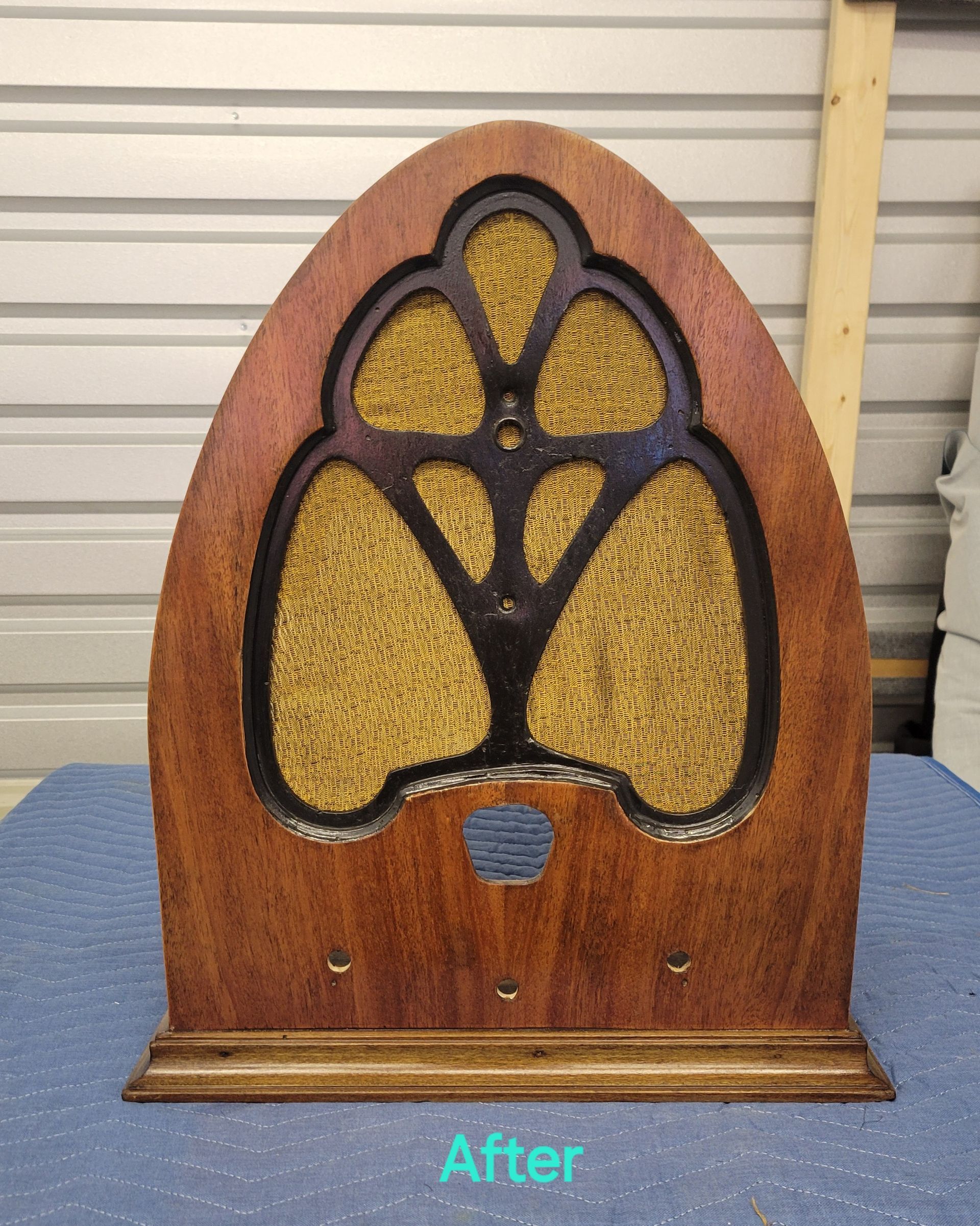 A wooden radio is sitting on a blue table with the words after below it