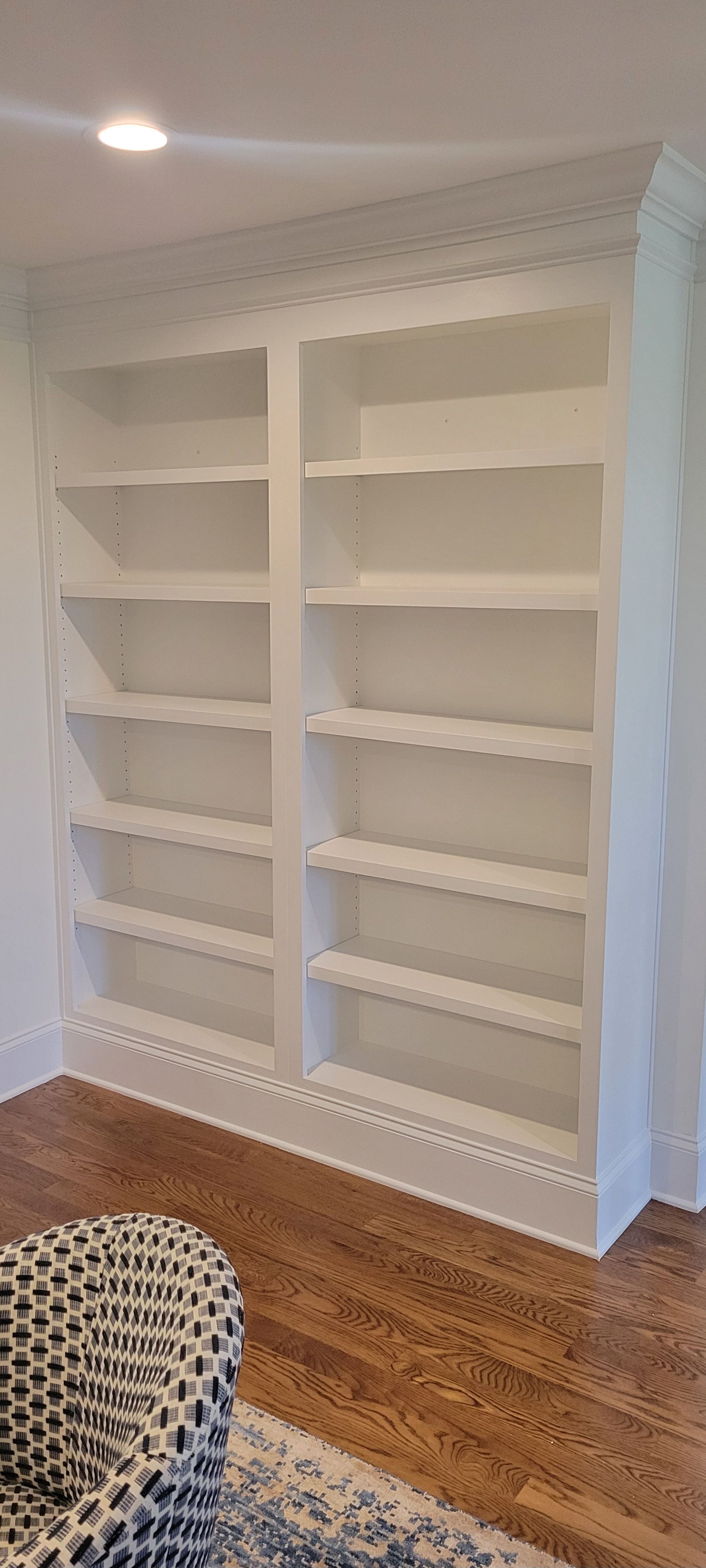 A living room with a chair and a bookshelf.