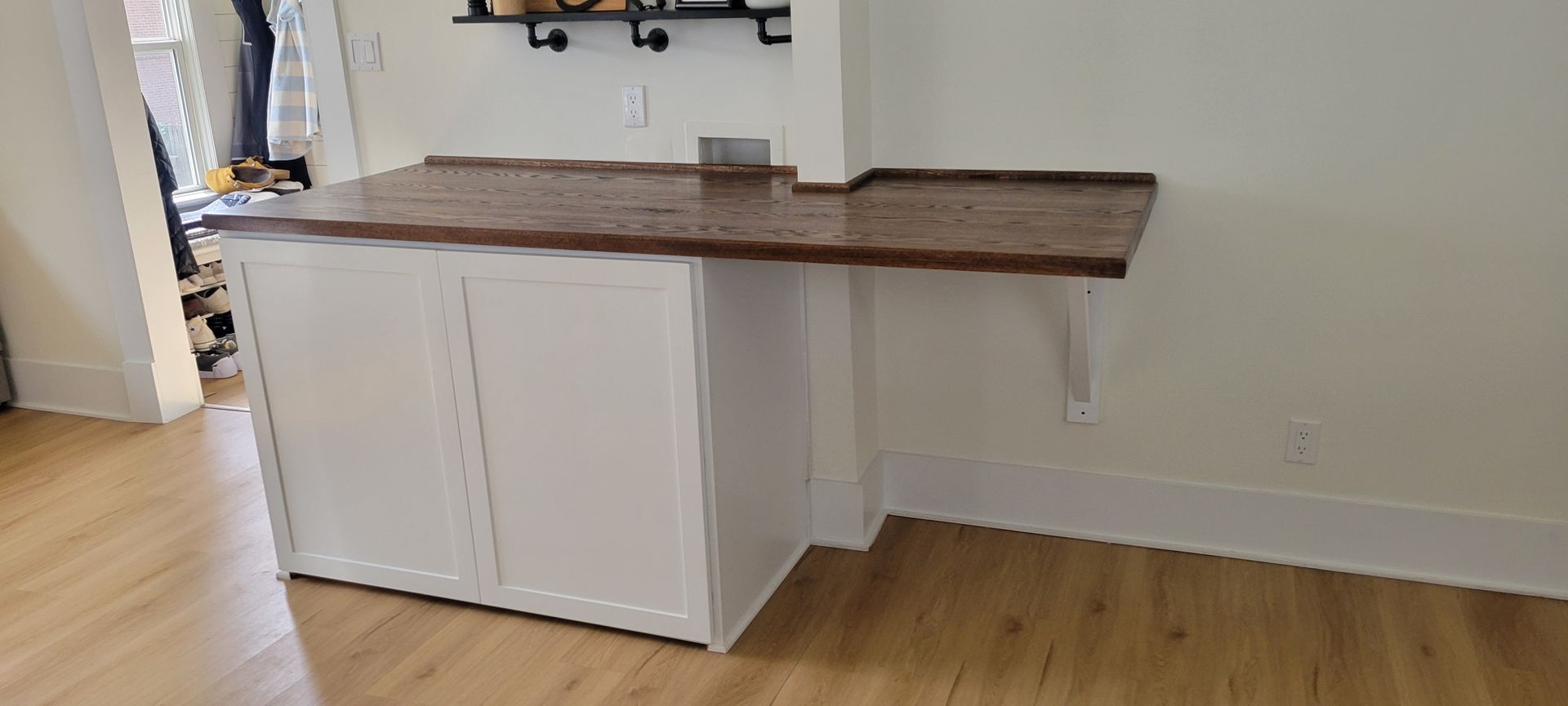 A kitchen with a wooden counter top and white cabinets.