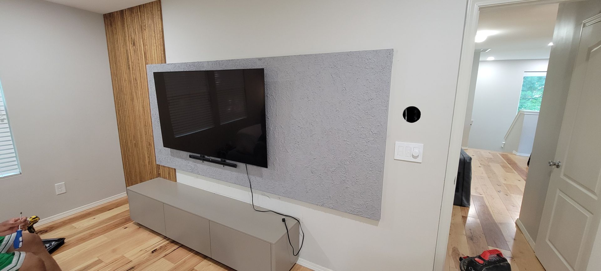 A living room with a flat screen tv mounted on the wall.