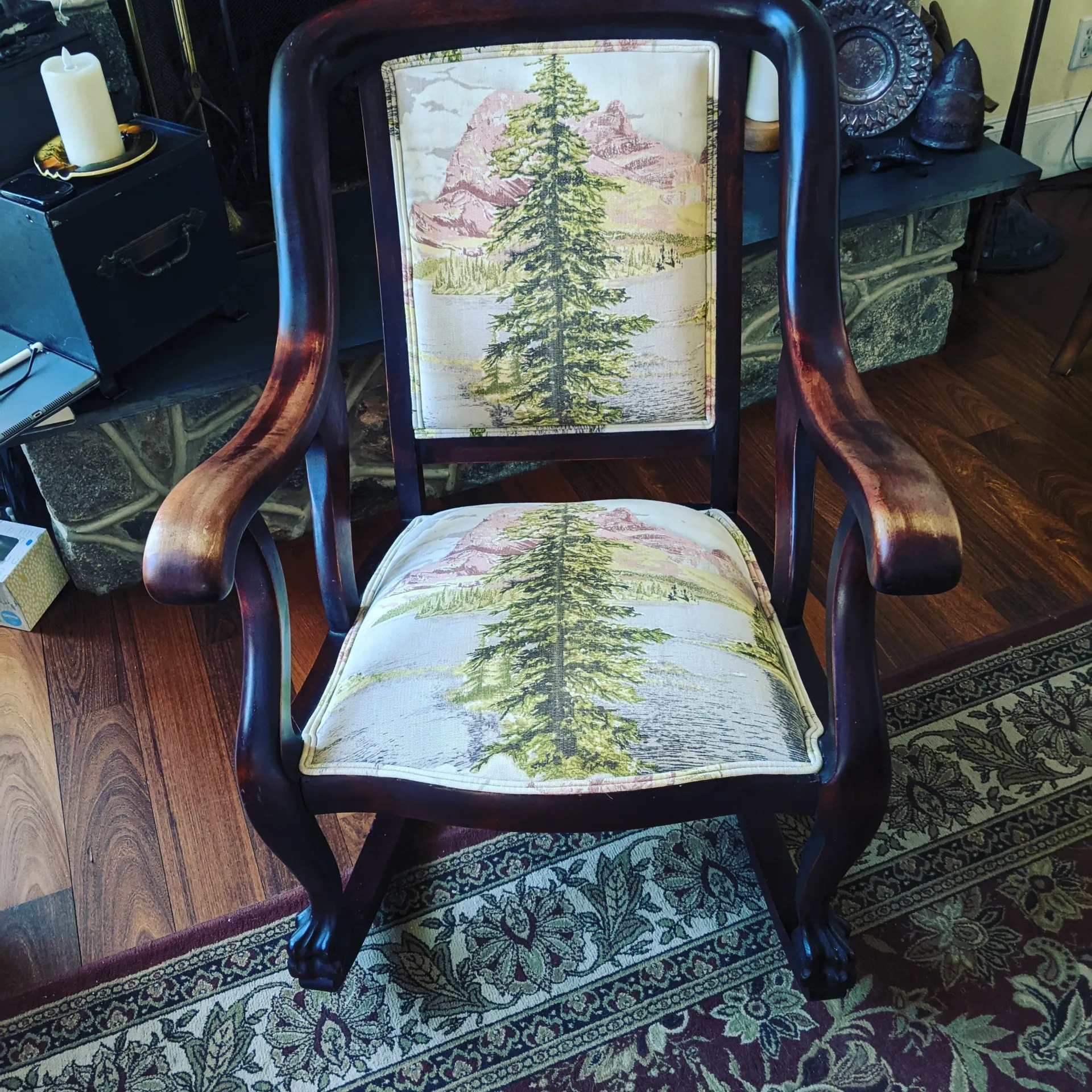 A rocking chair with a tree on the back of it