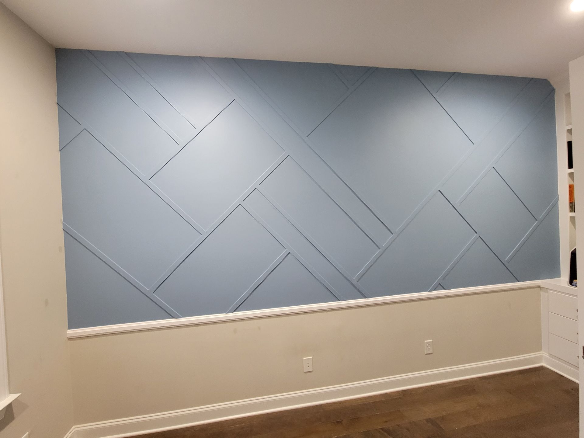 A room with a blue wall and a wooden floor