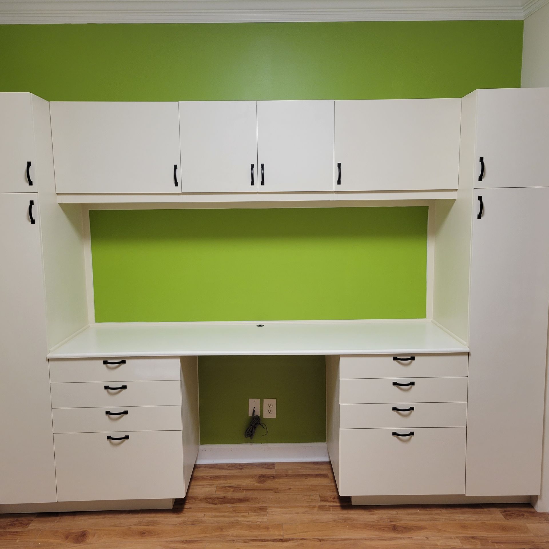 A room with green walls and white cabinets