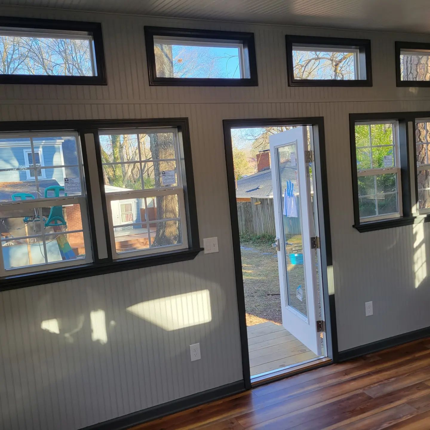 A room with a lot of windows and a door that is open.