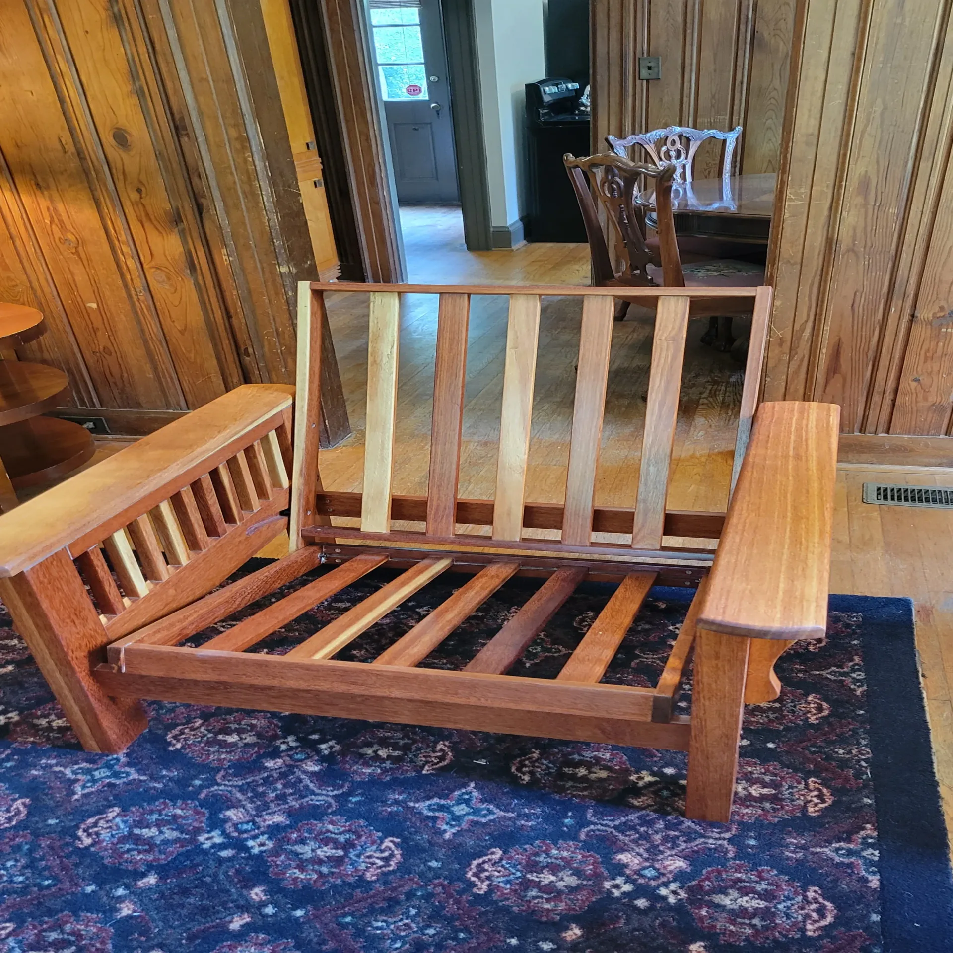 A wooden chair is sitting on a rug in a living room