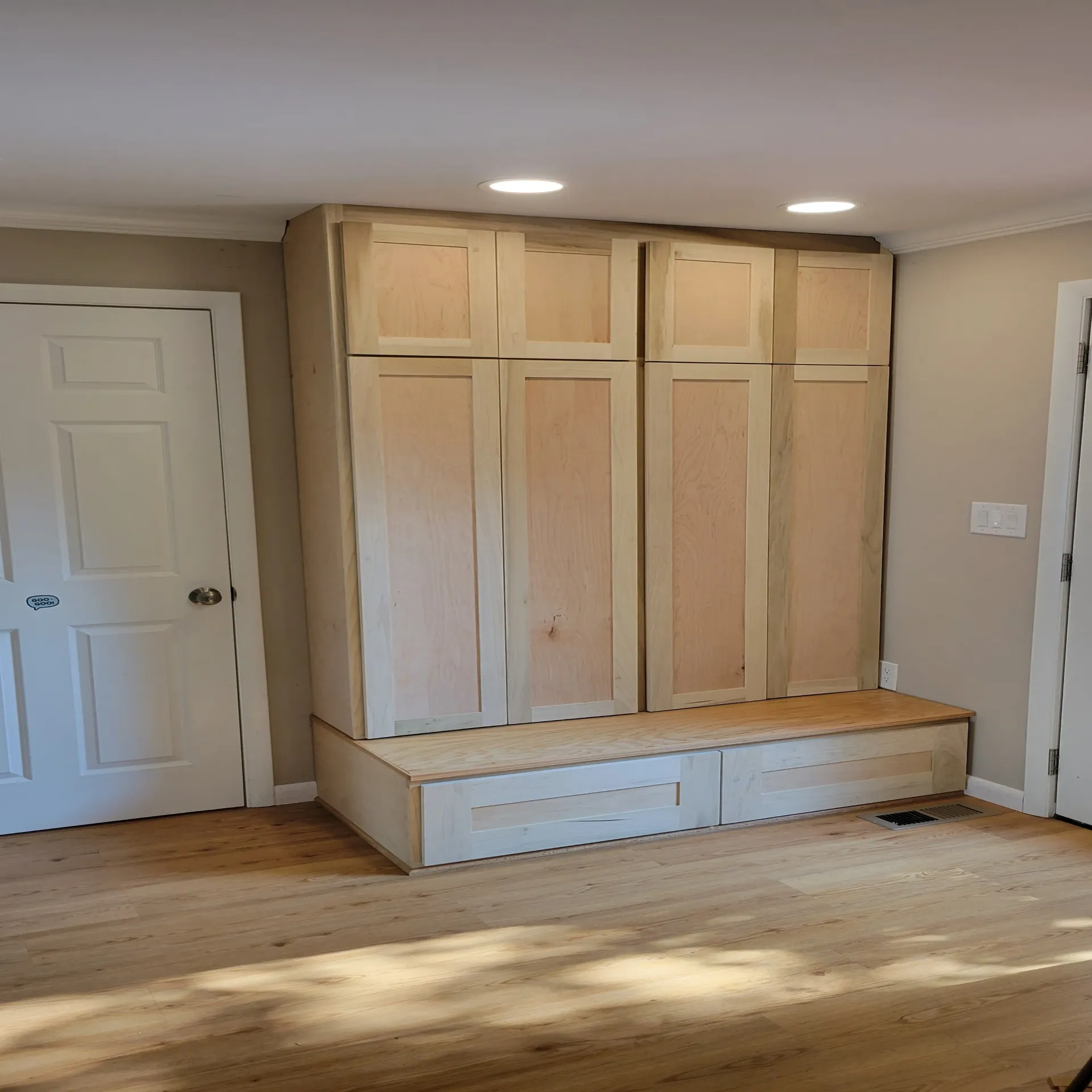 A room with wooden cabinets and a wooden bench.