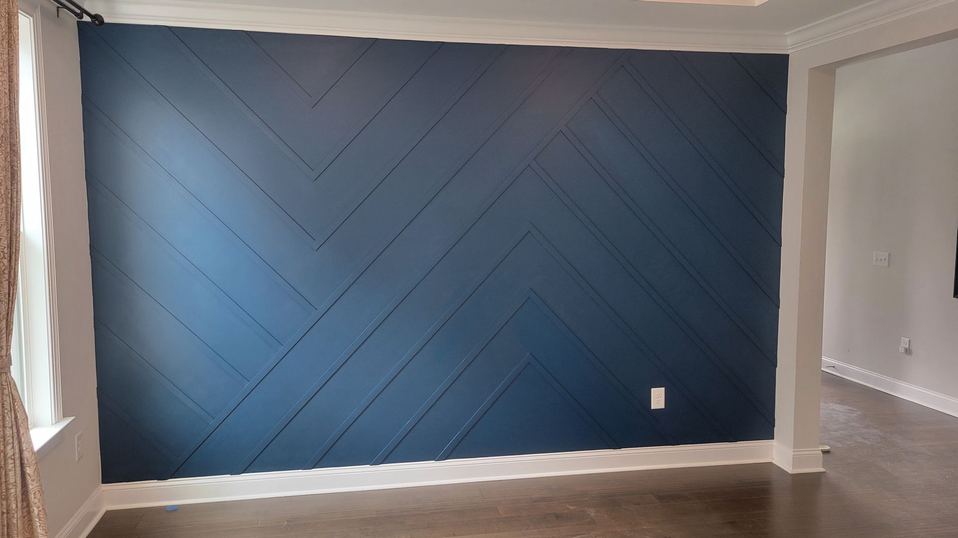 A living room with a blue wall and a wooden floor.