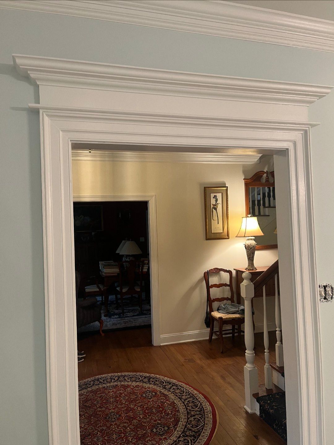 A doorway leading to a living room with a rug and stairs.