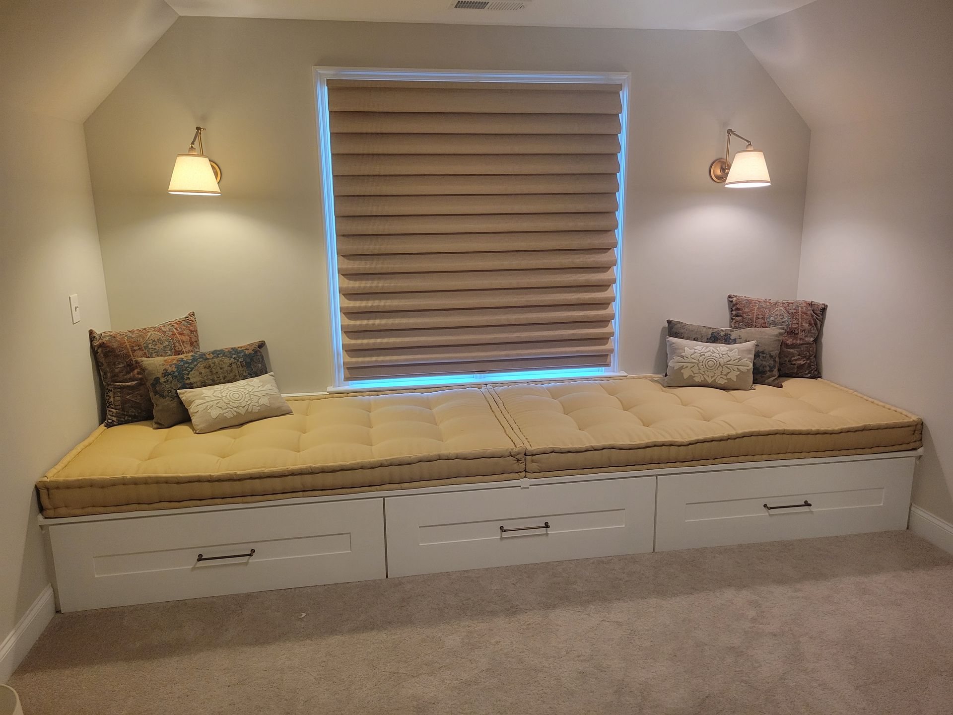 A window seat with drawers underneath it in a room with a window.