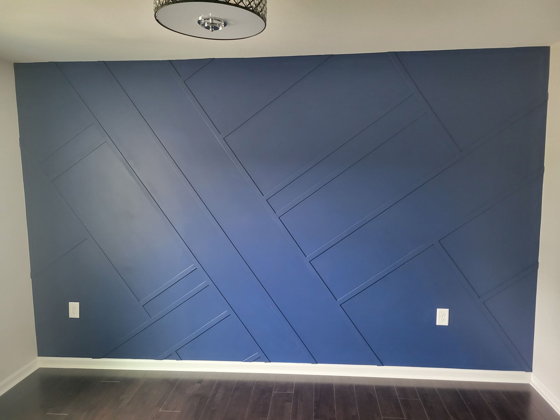 A room with a blue wall and a wooden floor.