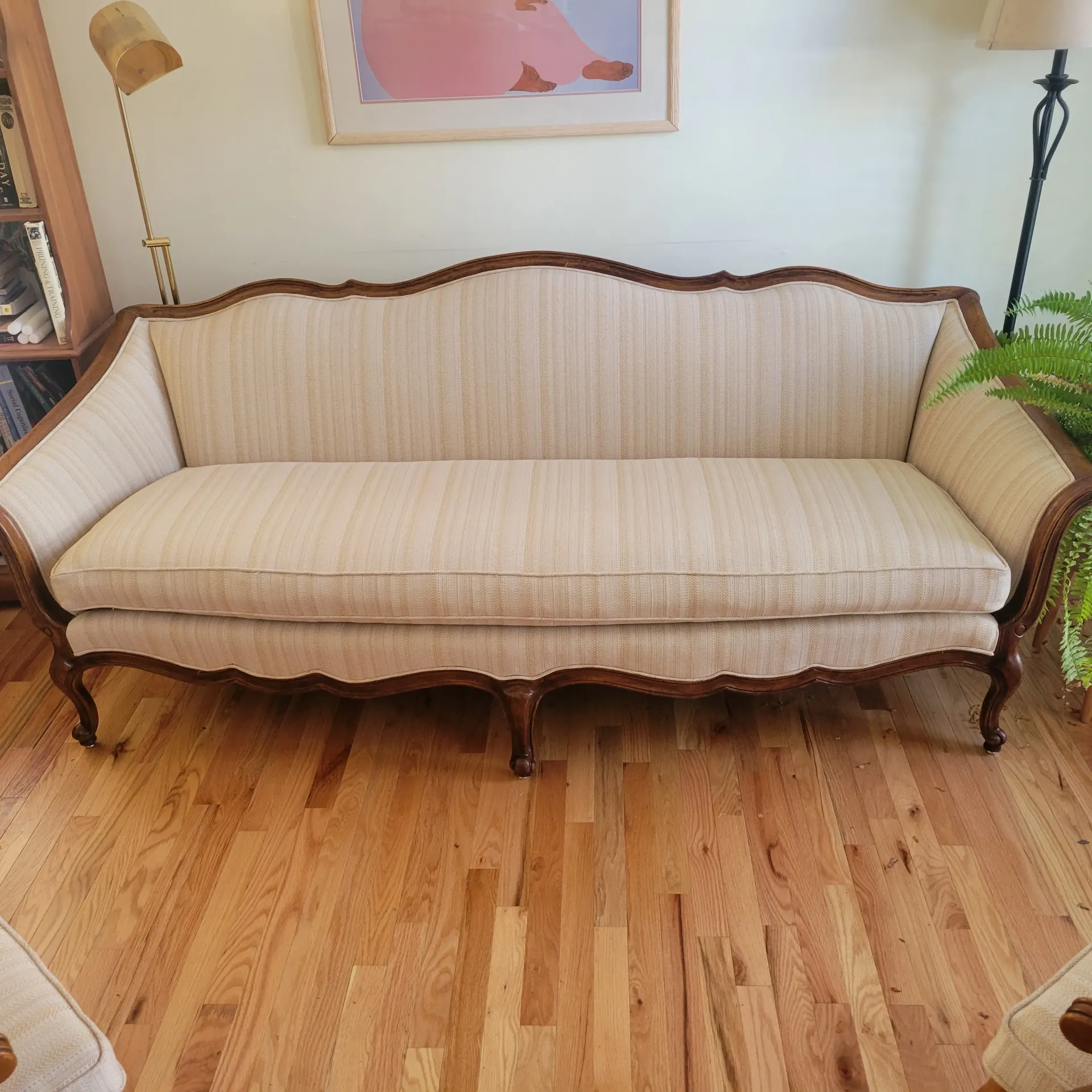 A couch is sitting on a wooden floor in a living room.