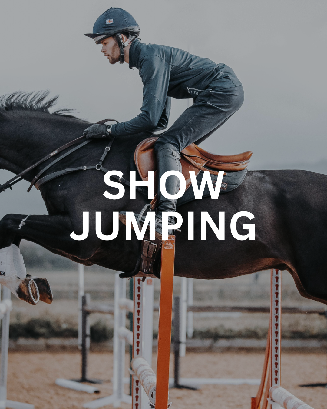 Equestrian rider in dark clothing jumping a horse over an orange fence. Show jumping text overlay.