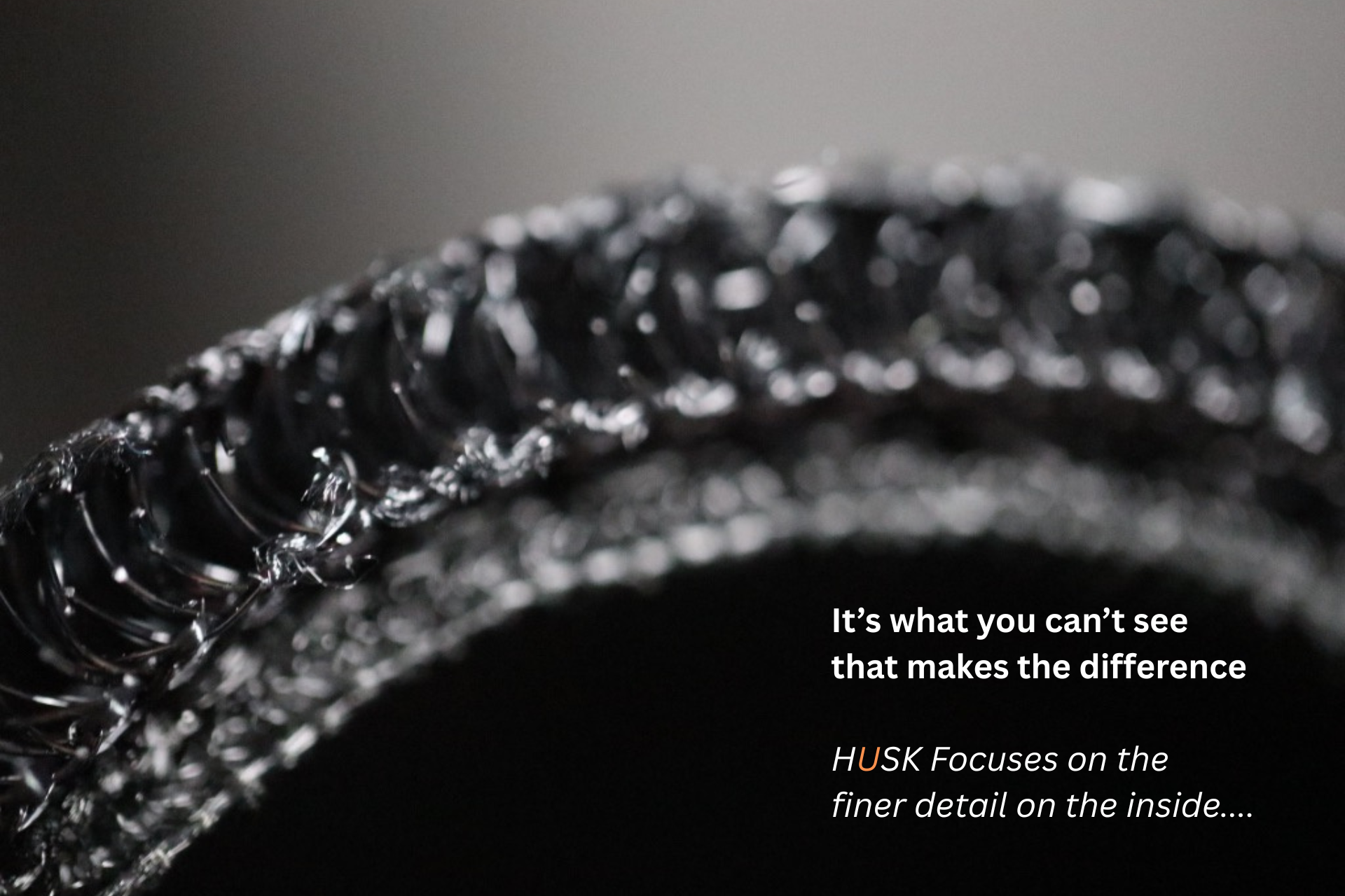 Black saddle on a white quilted pad labeled "HUSK" on a brown horse.