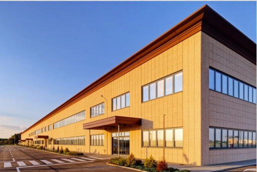 A large building with a lot of windows and a parking lot in front of it