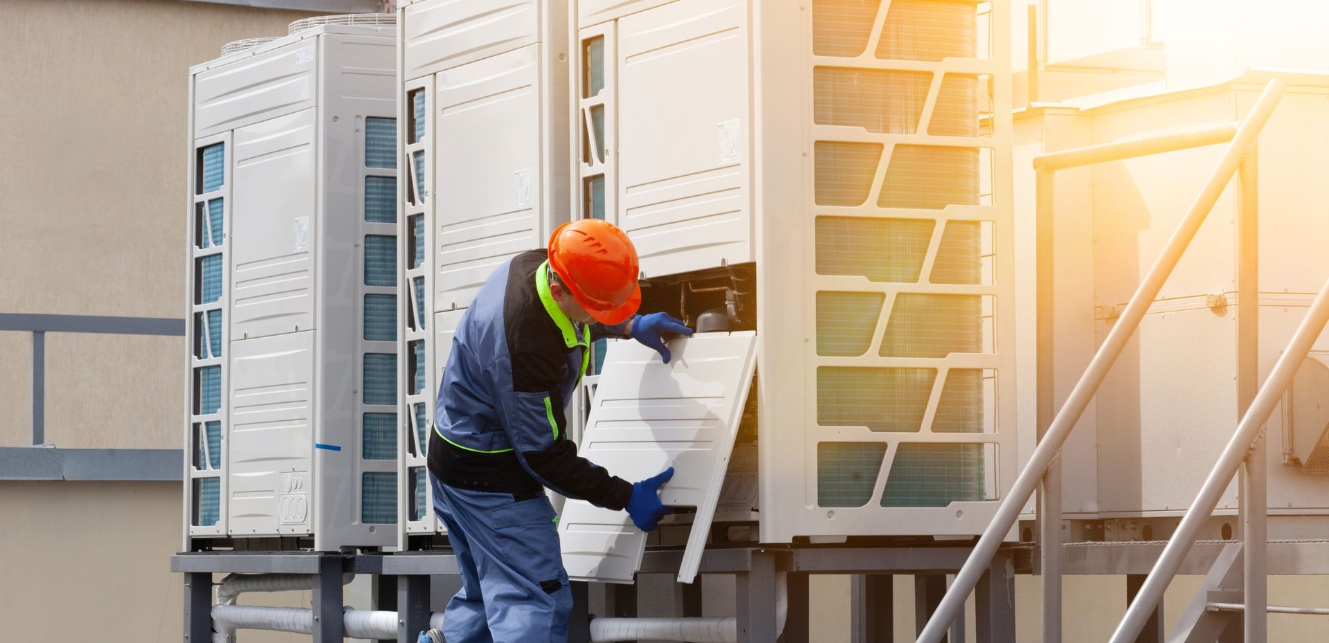 A man is cleaning an air conditioner with a brush.