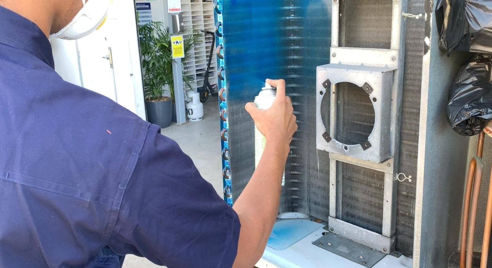 A man is installing an air conditioner on the wall.