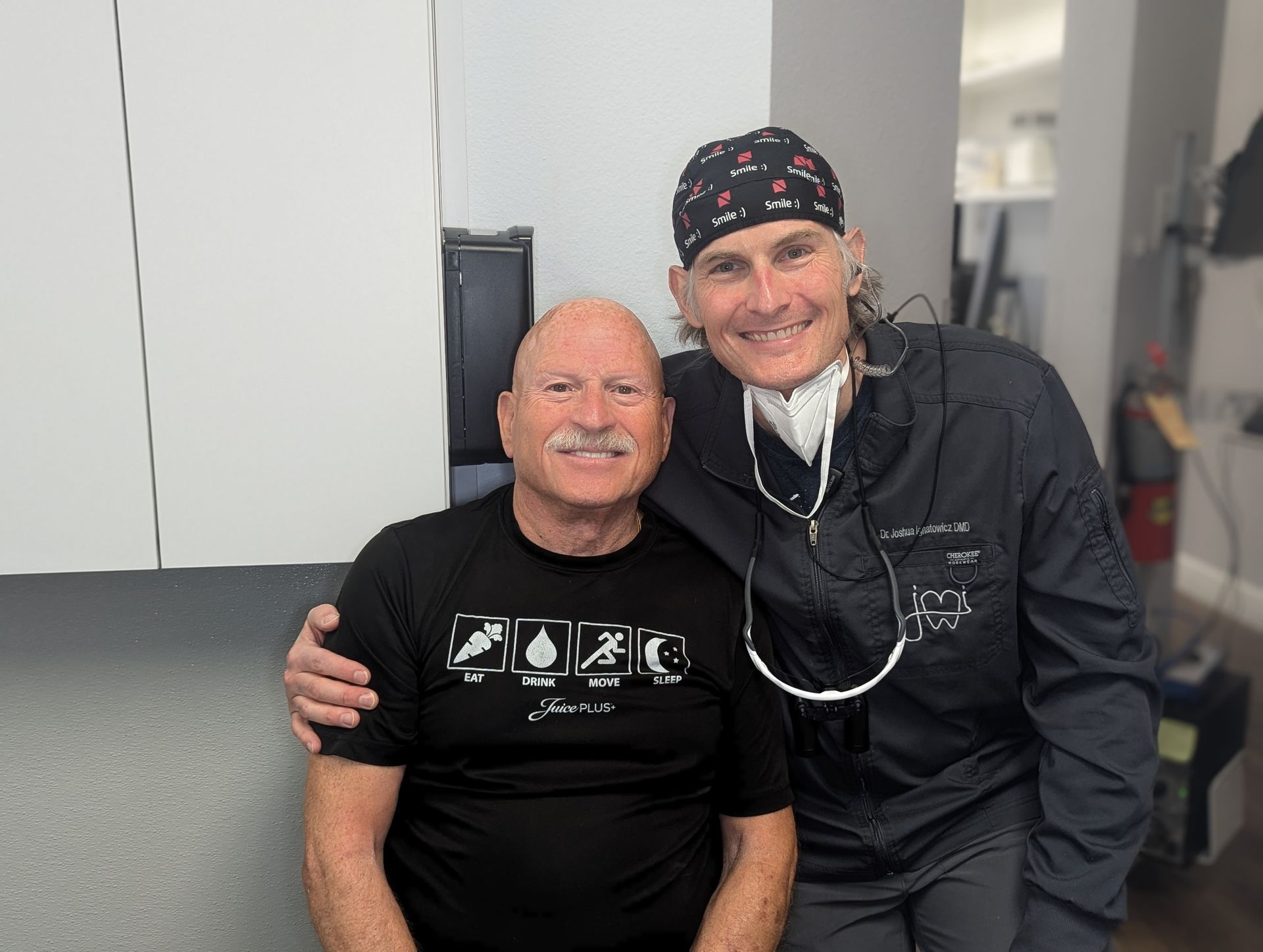 A dentist and a patient are posing for a picture in a dental office.