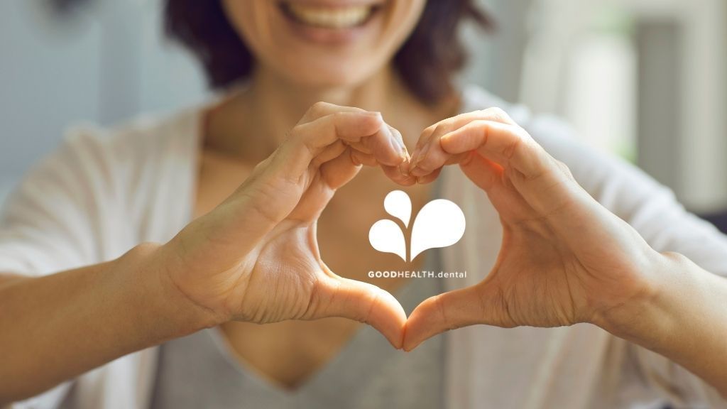 A woman is making a heart shape with her hands.