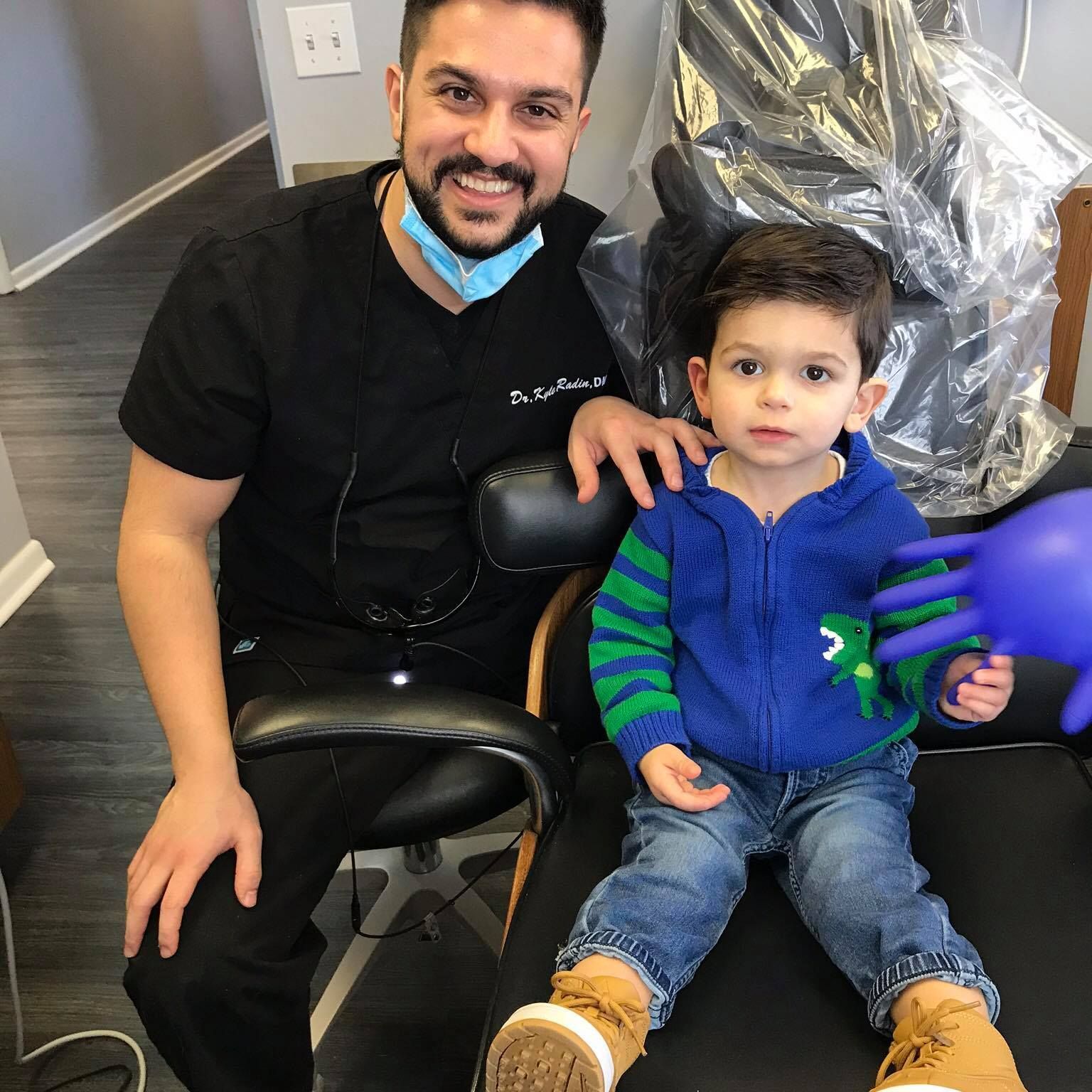 Get dental care for the whole family in Solon 44139 A dentist is sitting next to a little boy in a dental chair