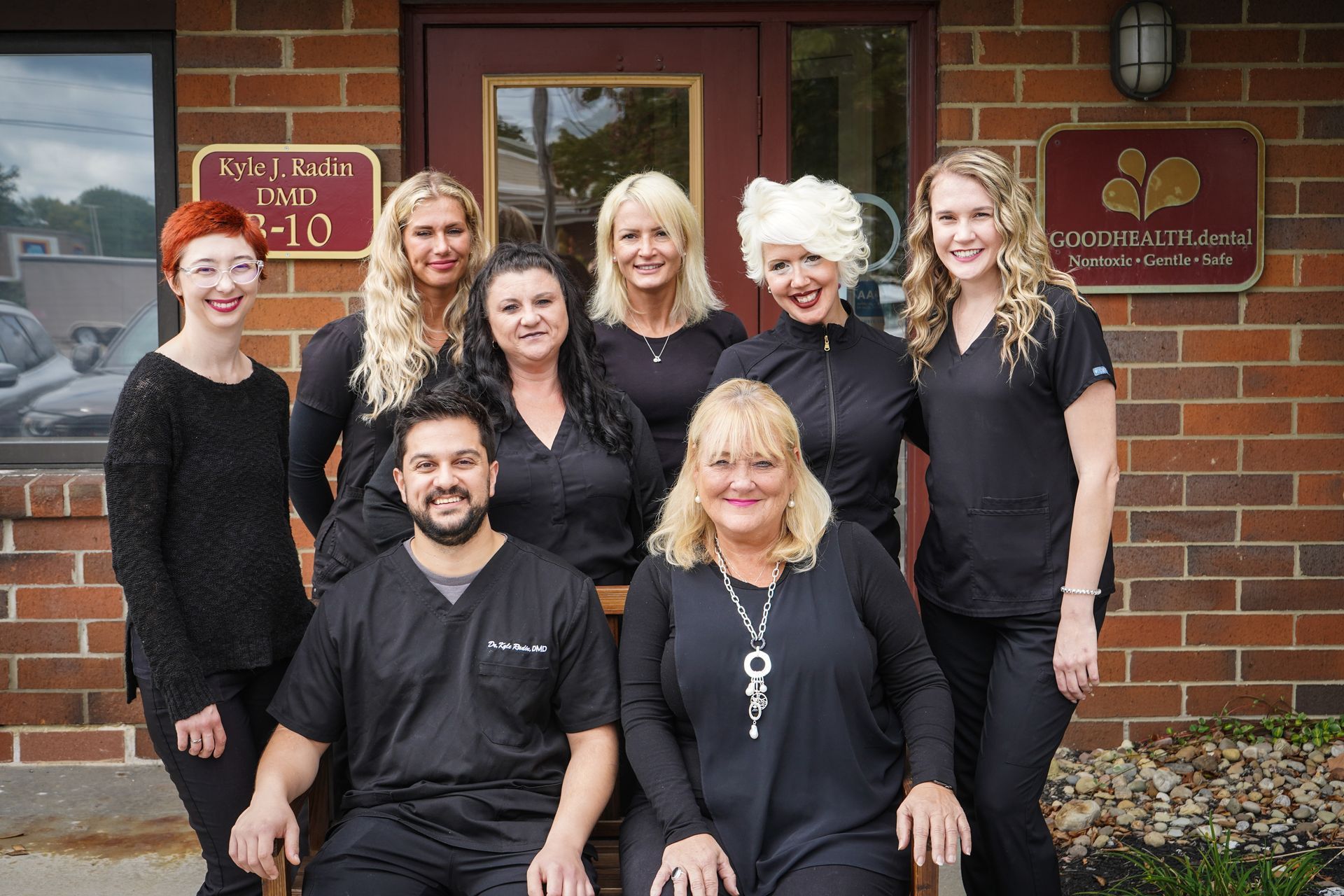 Get root canals, dentures, snap-on smiles, and smile makeovers in Solon 44139 A group of people are posing for a picture in front of a brick building.