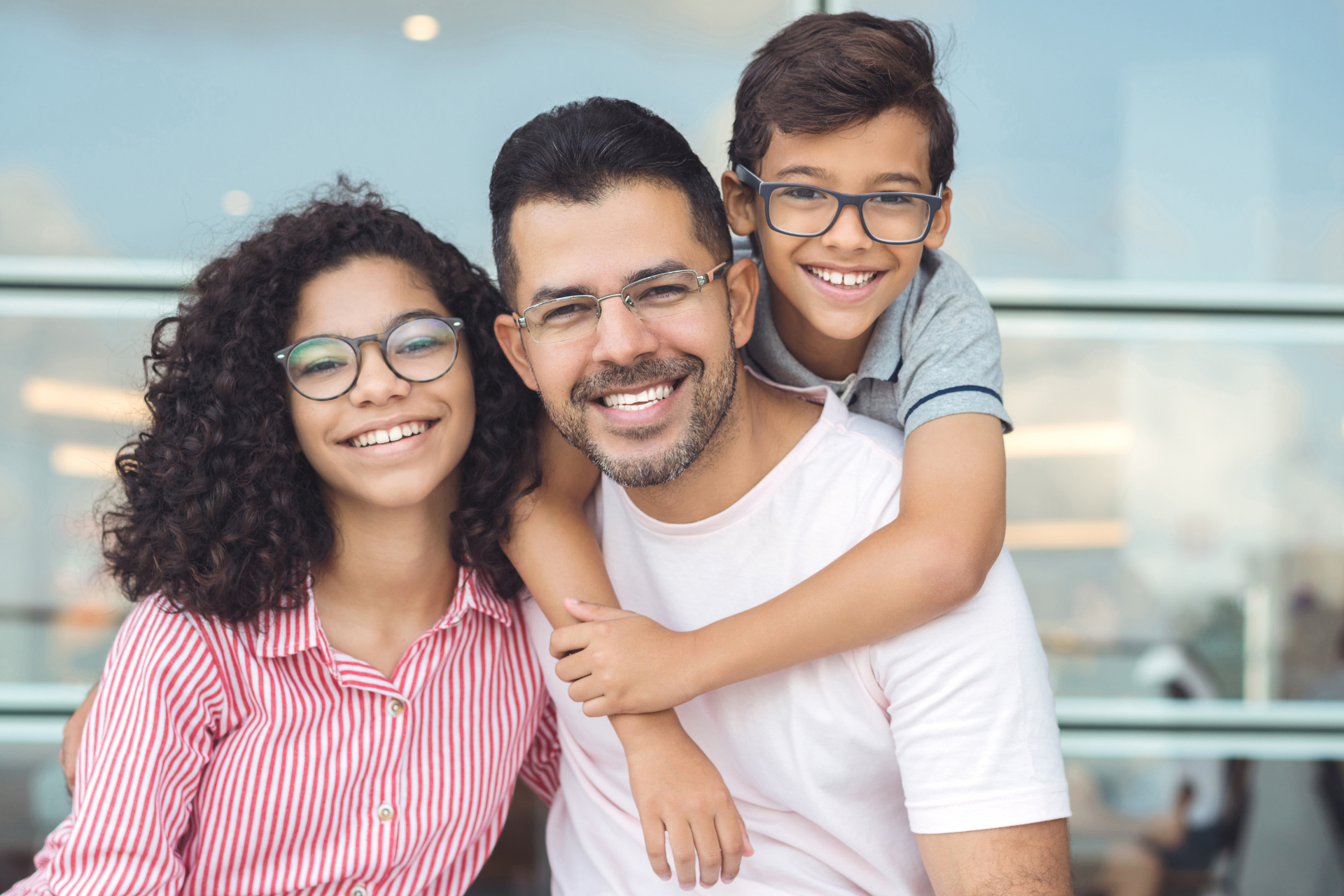 A man and two children wearing glasses are posing for a picture.