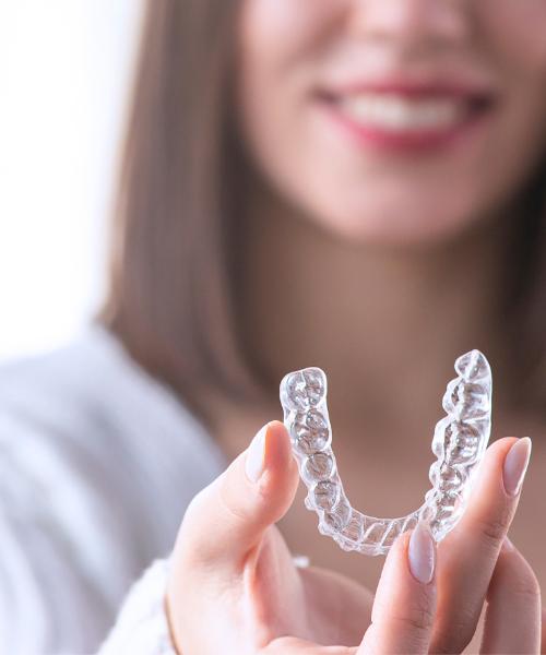 A woman is holding a clear brace in her hands.