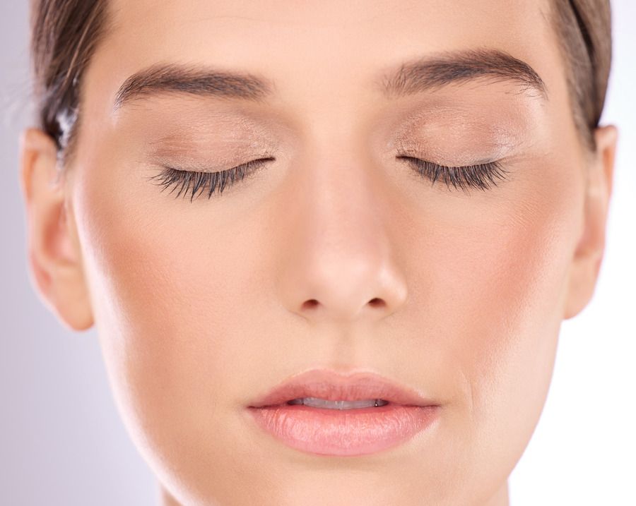 A close up of a woman 's face with her eyes closed.