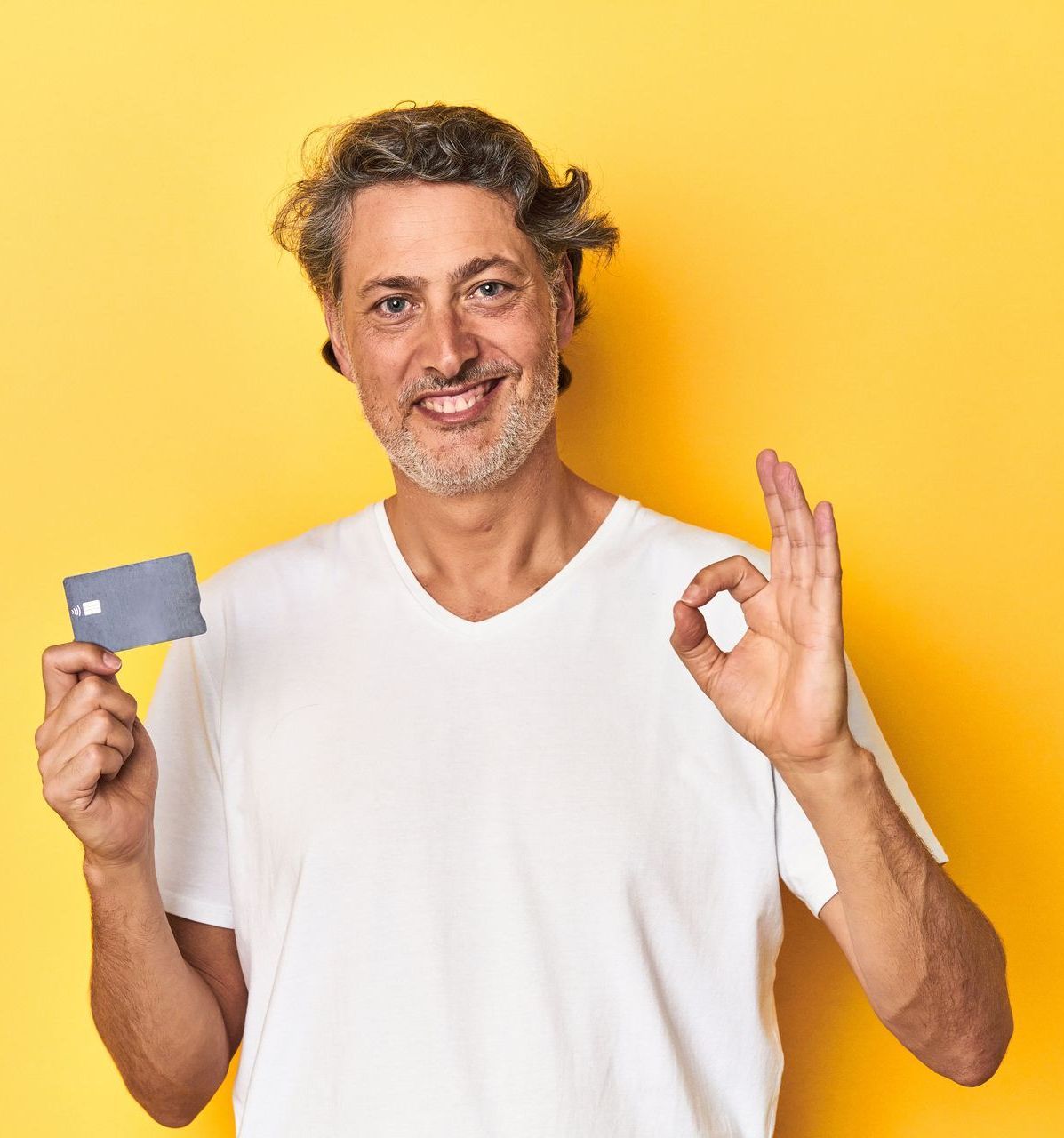 Uomo sorridente con in mano una carta di credito