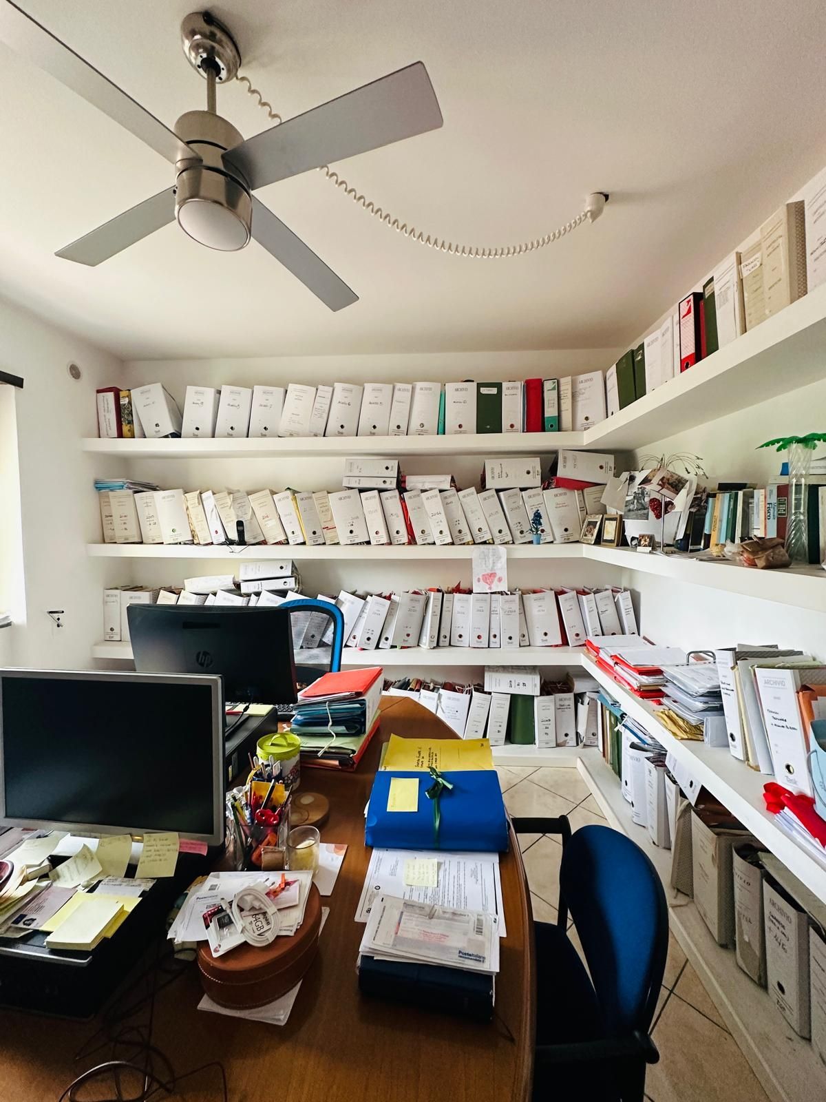 Un ventilatore da soffitto è appeso al soffitto sopra una scrivania