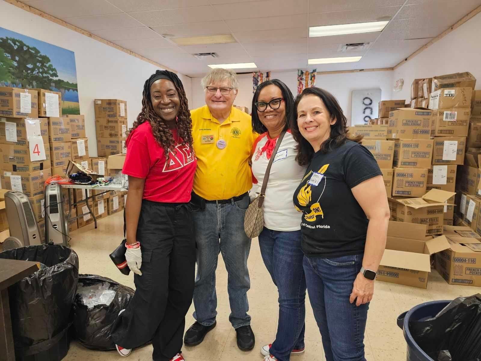 A group of people are posing for a picture in a room filled with boxes.