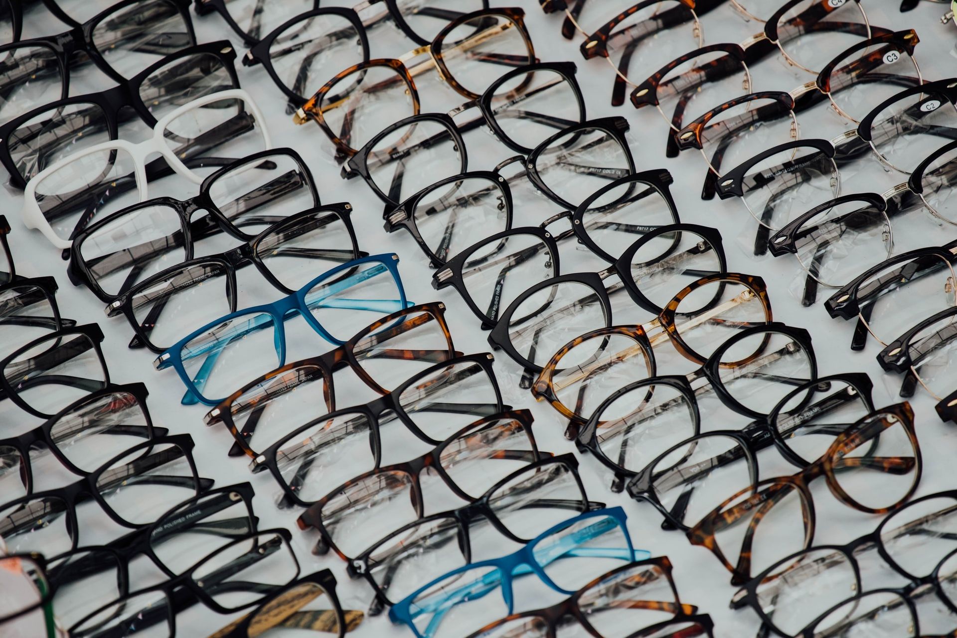 A bunch of glasses are lined up on a table.