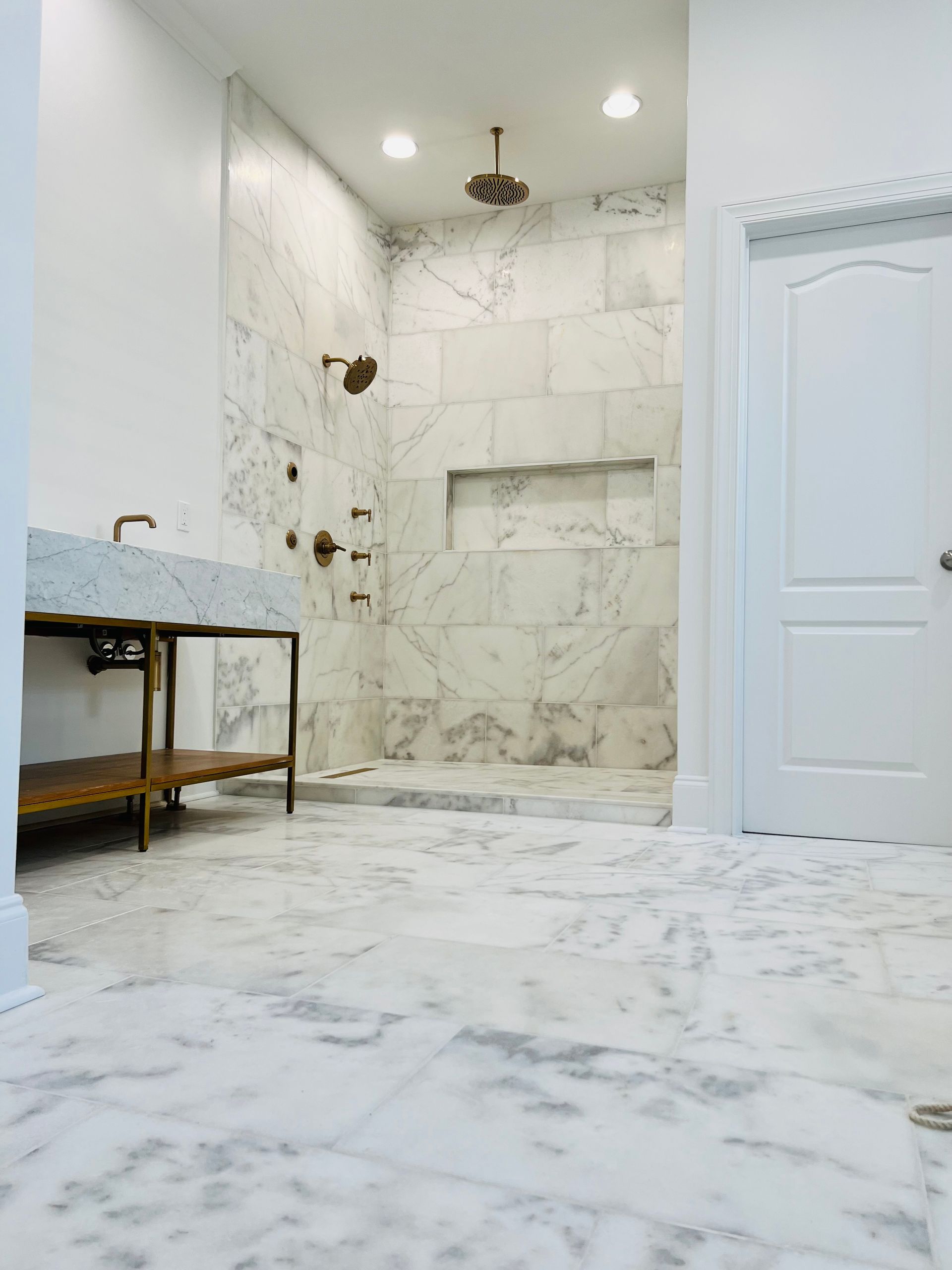 A bathroom with a walk in shower and a sink