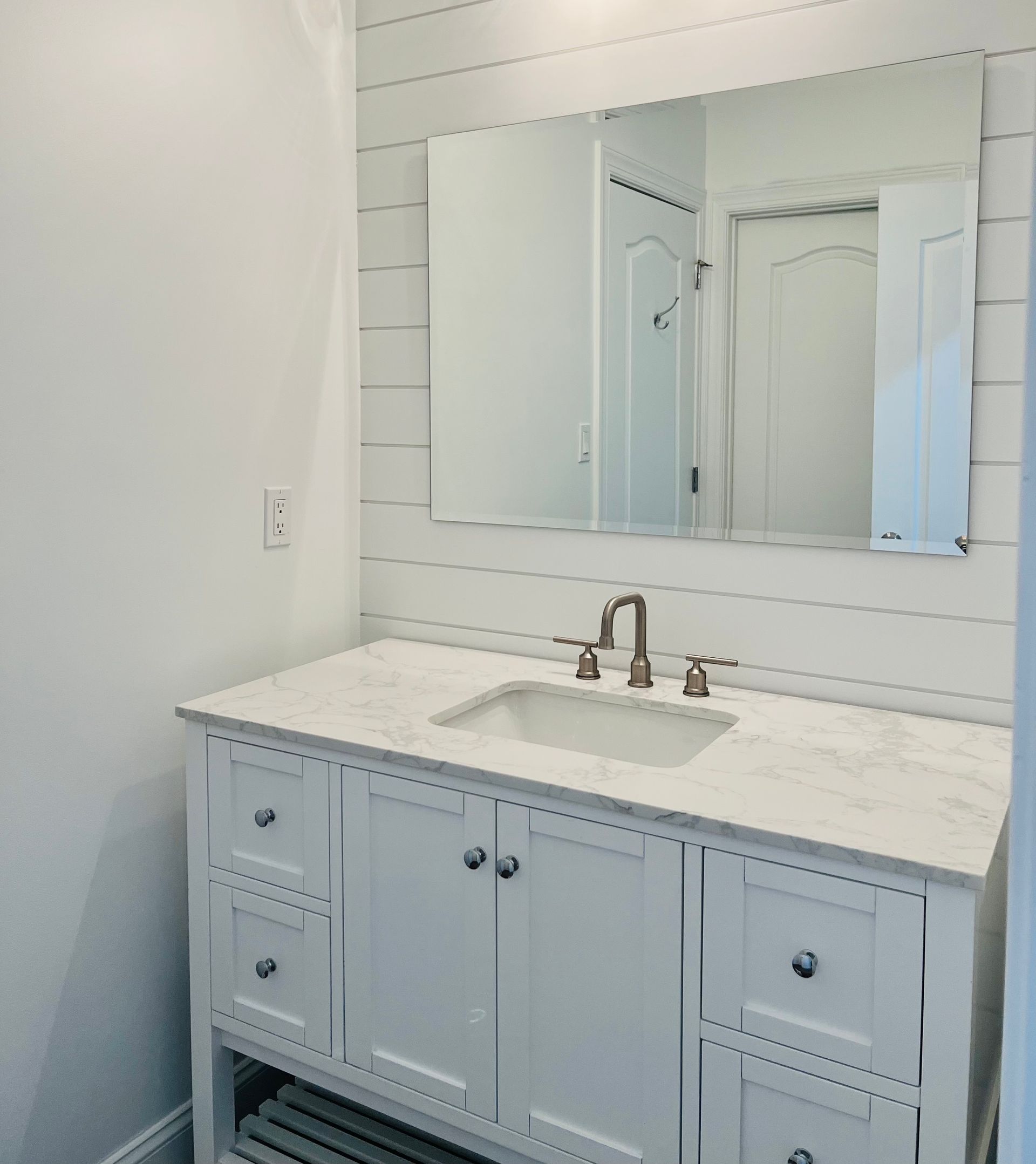 A bathroom with a sink , mirror and vanity.