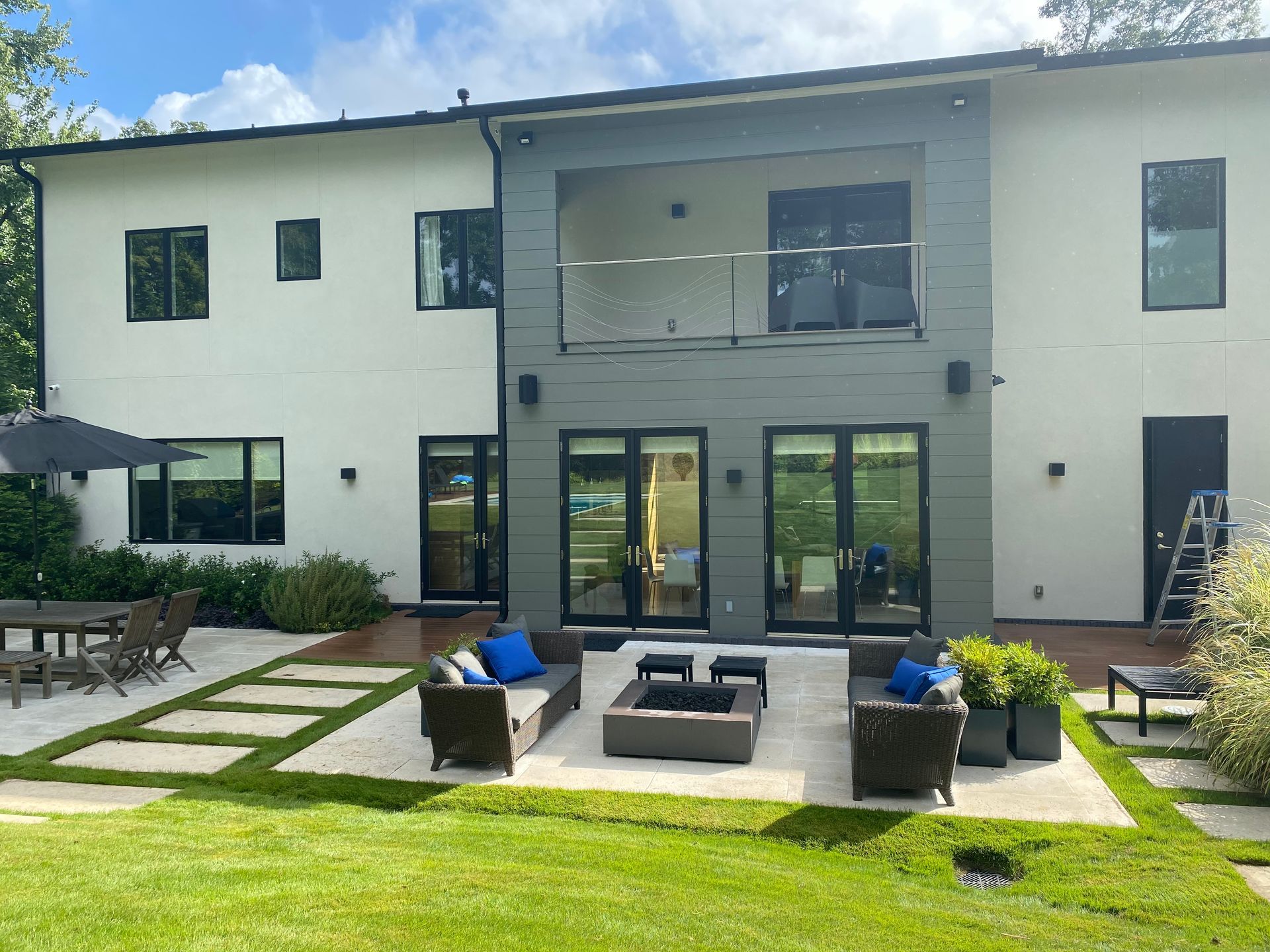 A large white house with a patio area in front of it.