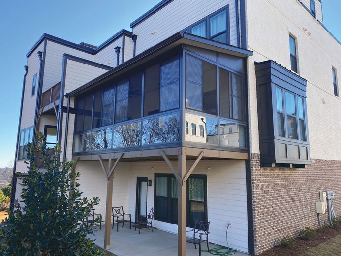 A large white building with a screened in porch