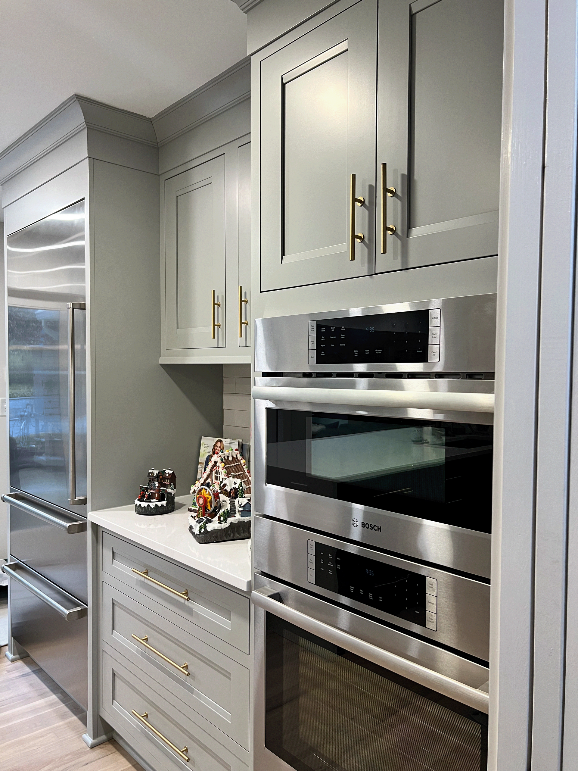 A kitchen with stainless steel appliances and gray cabinets.